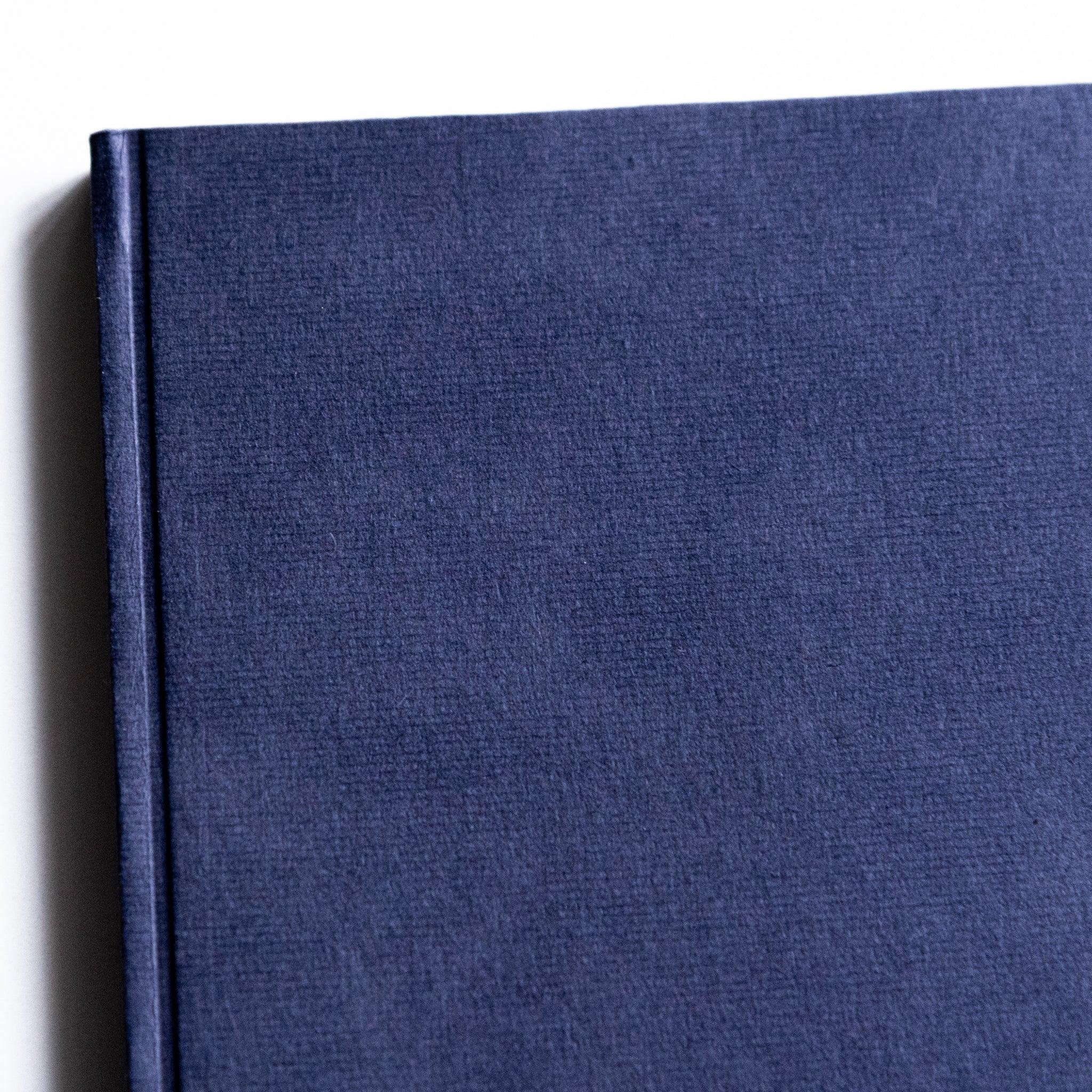 Dressco Bank Ledger Paper A6 notebook standing on end showing the full front cover and book height profile