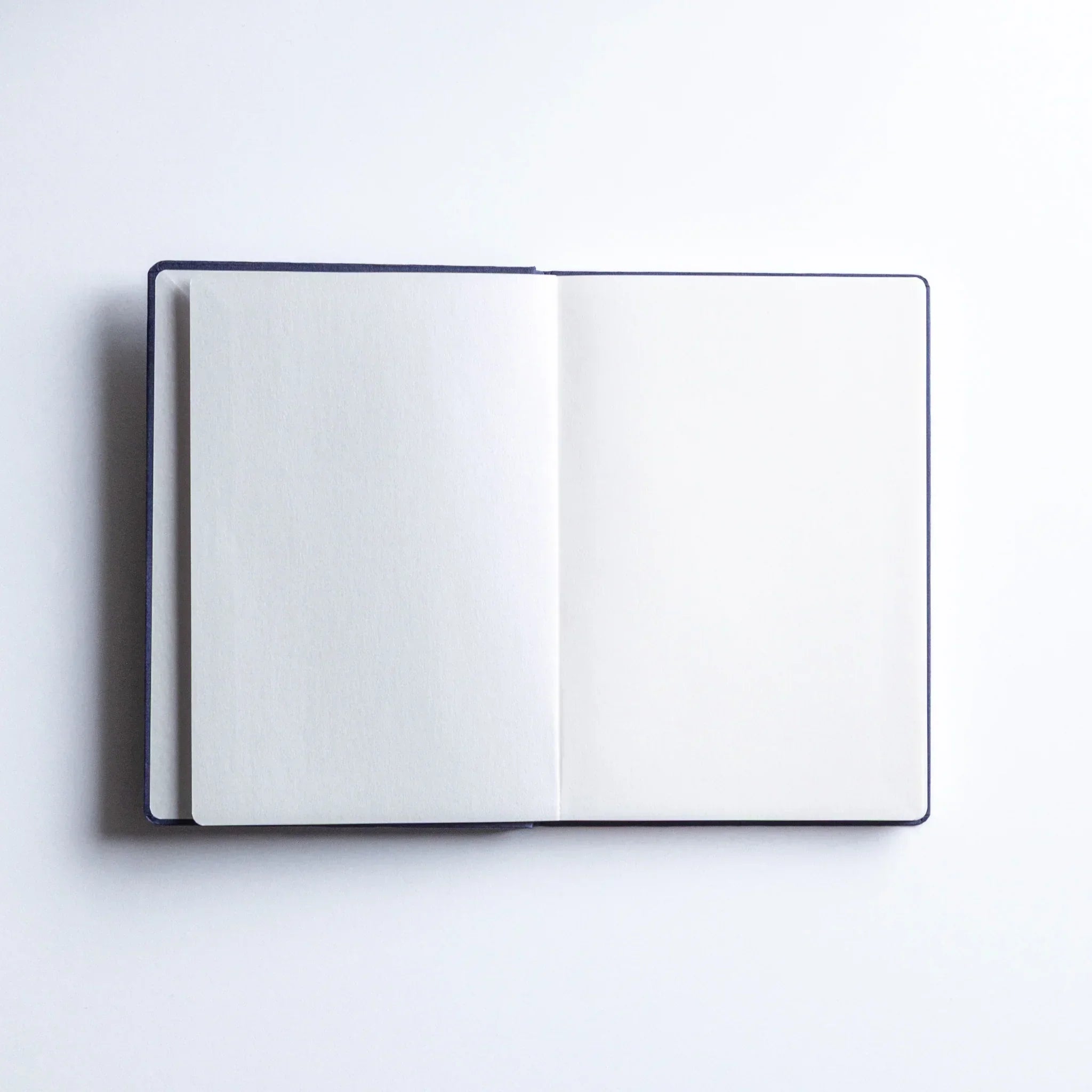 Dressco Bank Ledger Paper A6 notebook angled close-up showing the cover texture and binding edge detail visible