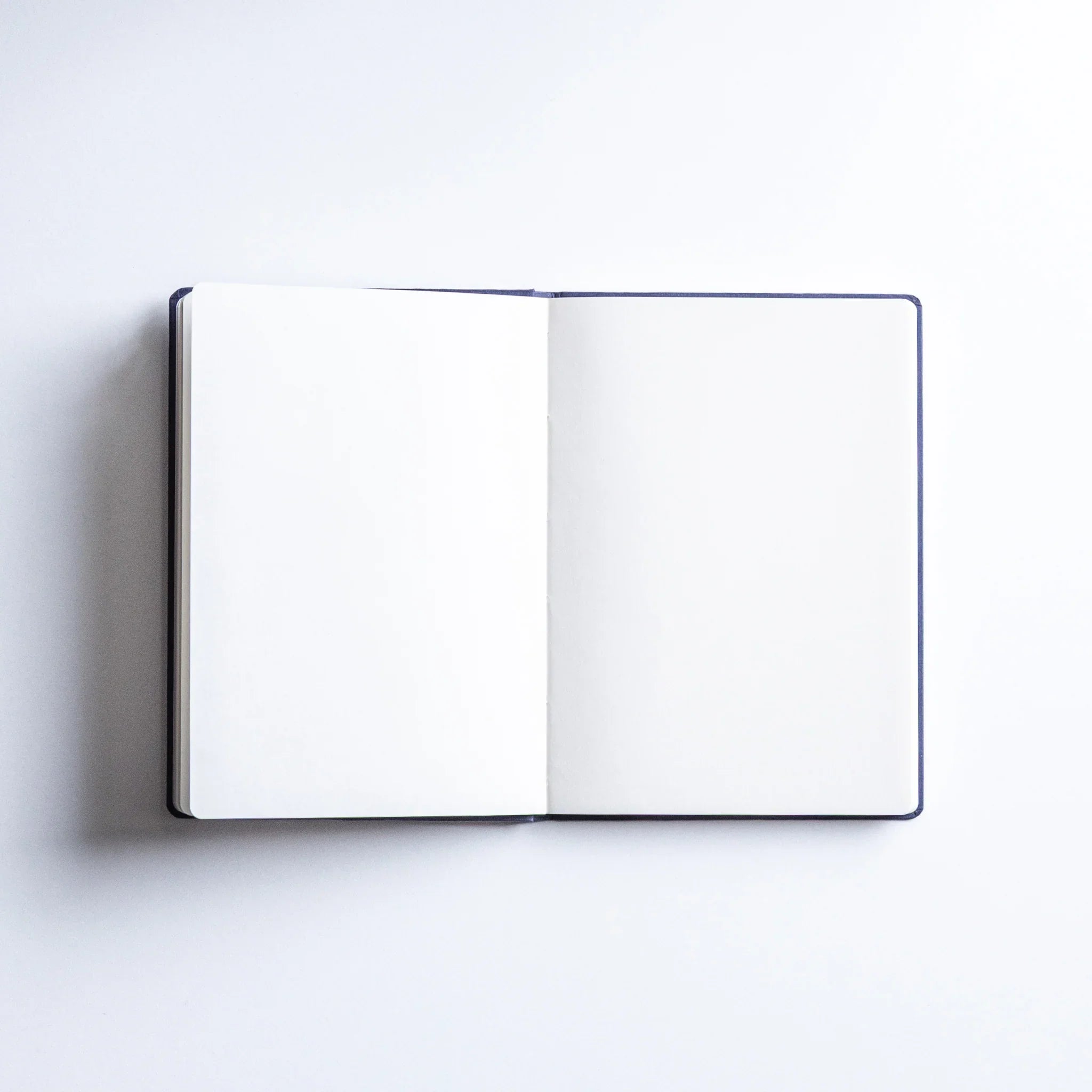 Close-up of Dressco Bank Ledger Paper A6 notebook showing the paper edge texture and binding construction quality