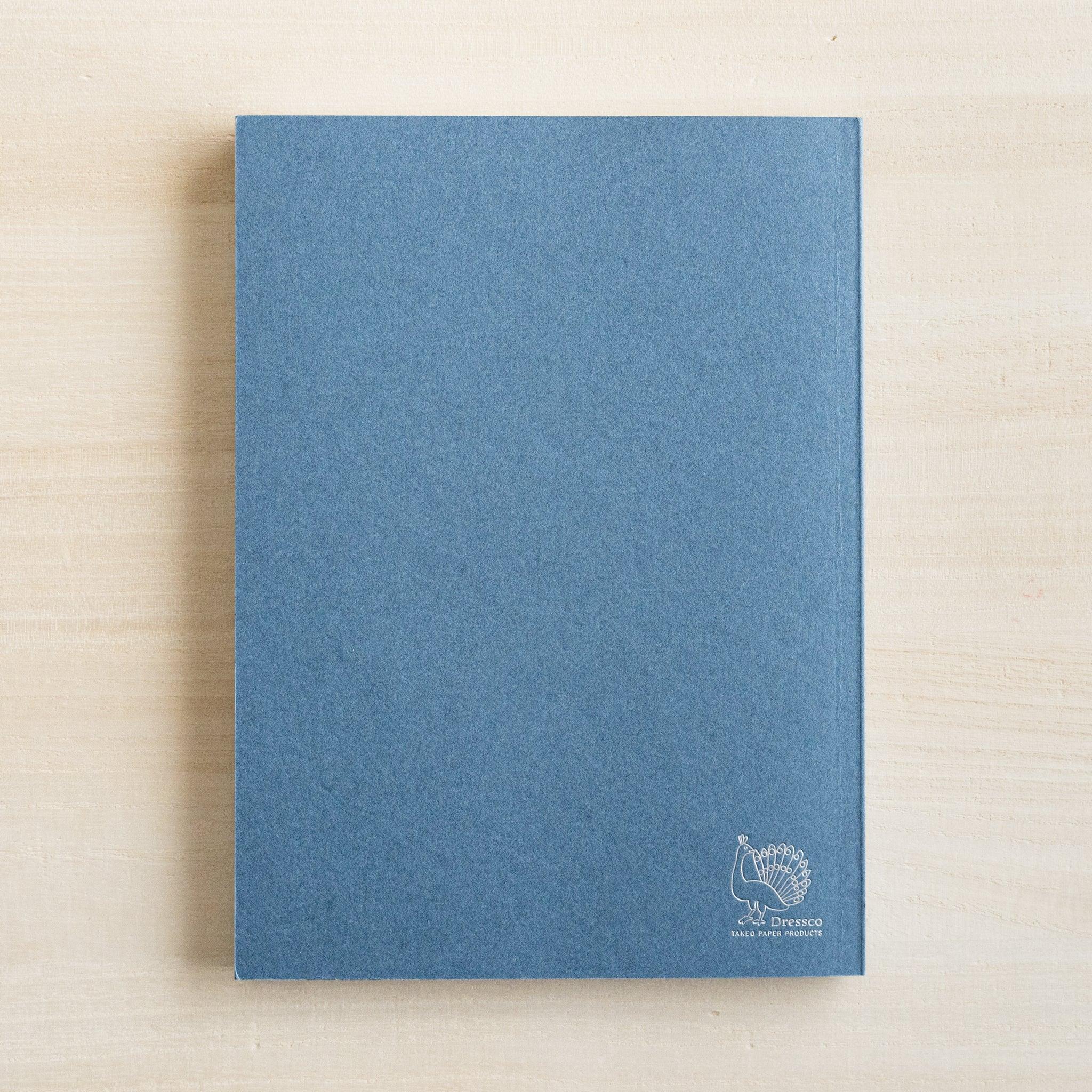 Open indigo blue Dressco notebook showing thin onion skin interior pages and cover design for writing and personal corresp