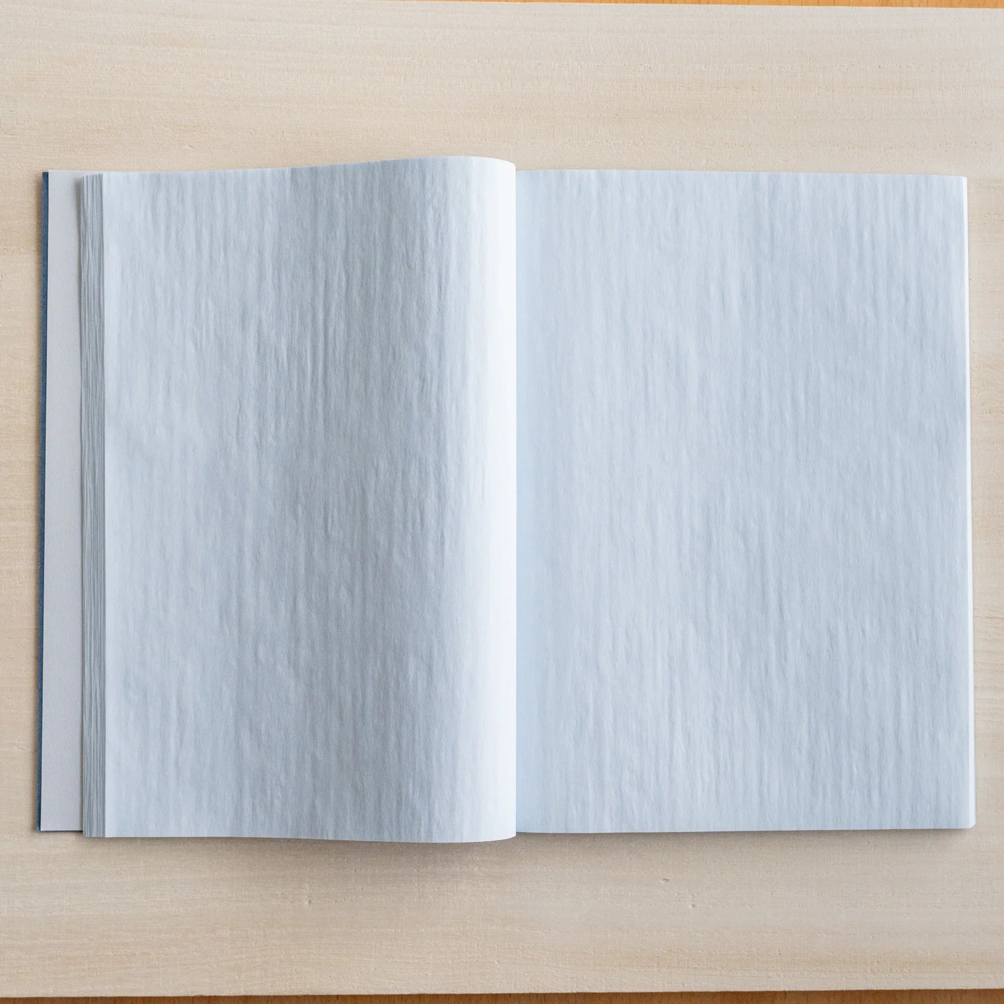 Indigo blue notebook pages fanned showing thin paper translucency and page quantity showing product quality and design det