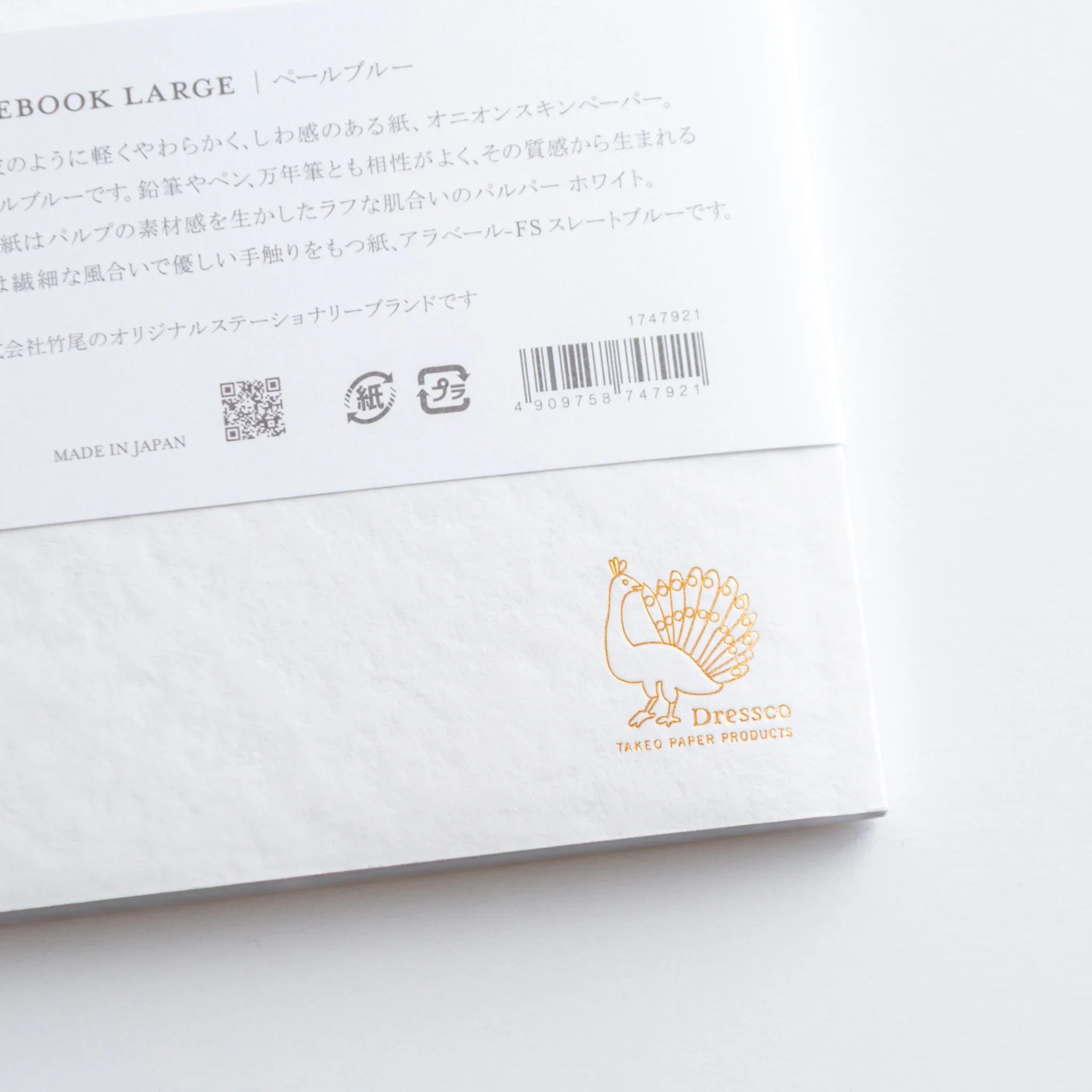 Close-up of Dressco Blue Onion Skin Japanese Notebook B6 back label with gold Dressco peacock logo.