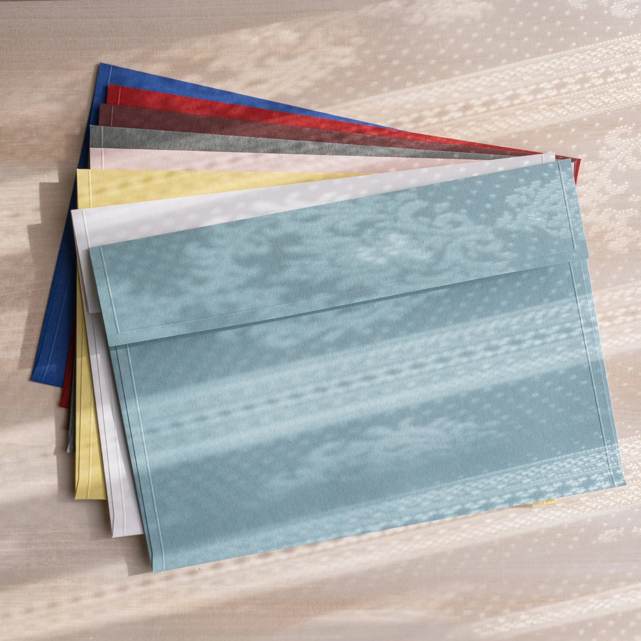Stack of Japanese embossed envelopes in assorted colors, shown from the back with flaps visible and textured paper surfaces