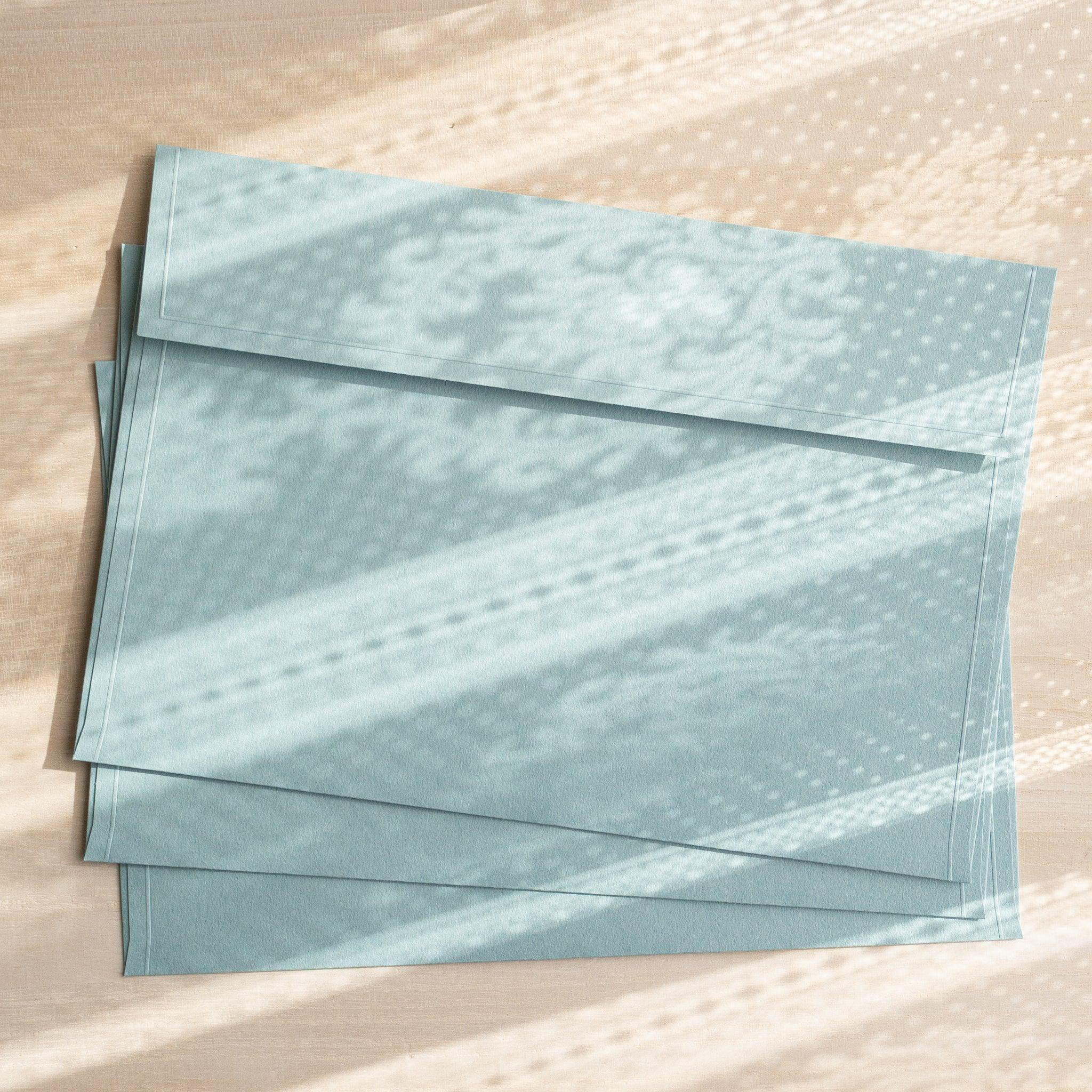 Dressco ivory large embossed envelope image five, overhead flat composition, with embossed surface, set of three