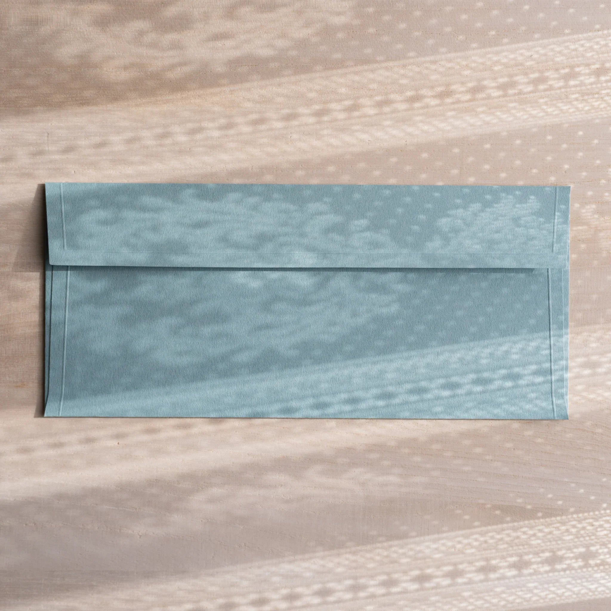 Dressco ivory medium embossed envelope image five, overhead flat composition, with embossed surface, set of three