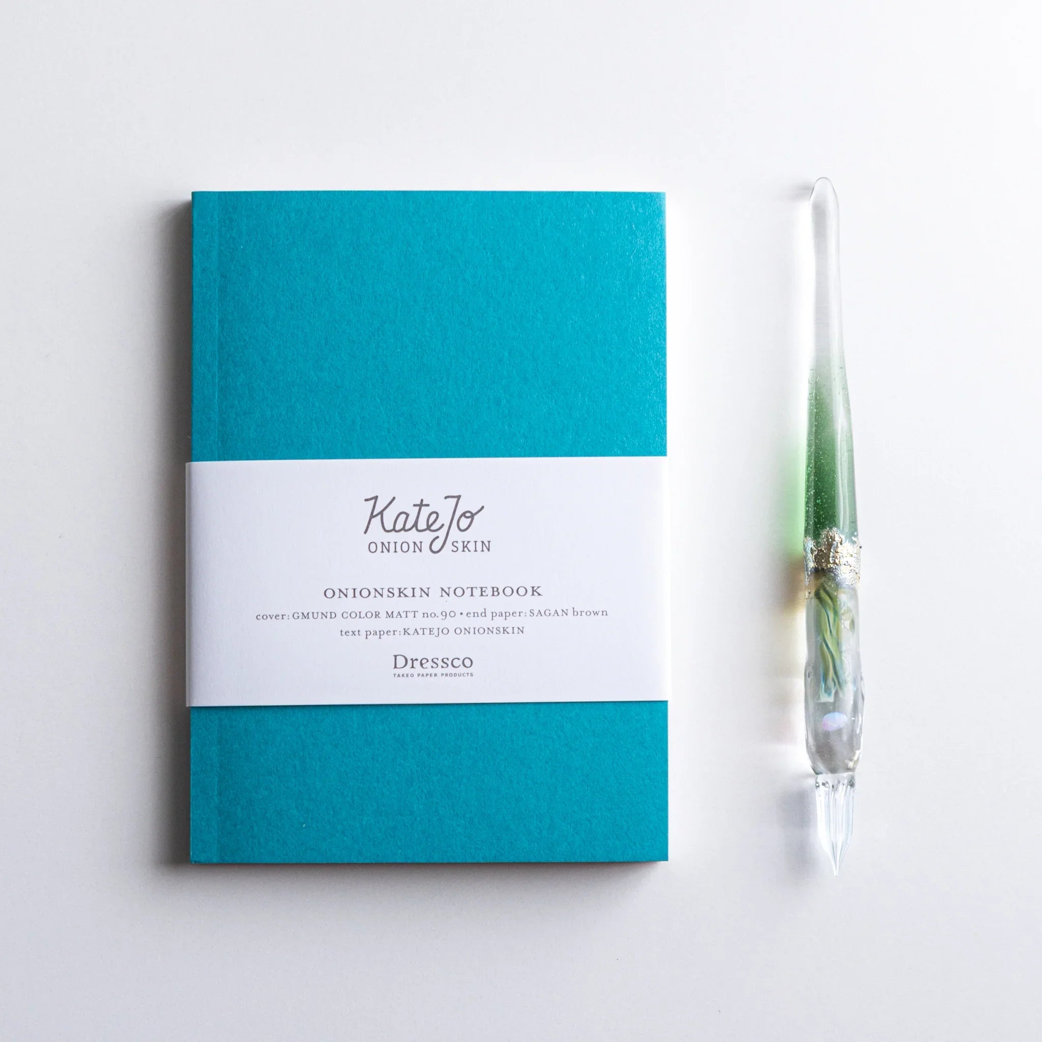 Dressco Teal Blue Onion Skin Japanese Notebook A6 showing texture and printed label and glass-pen beside.