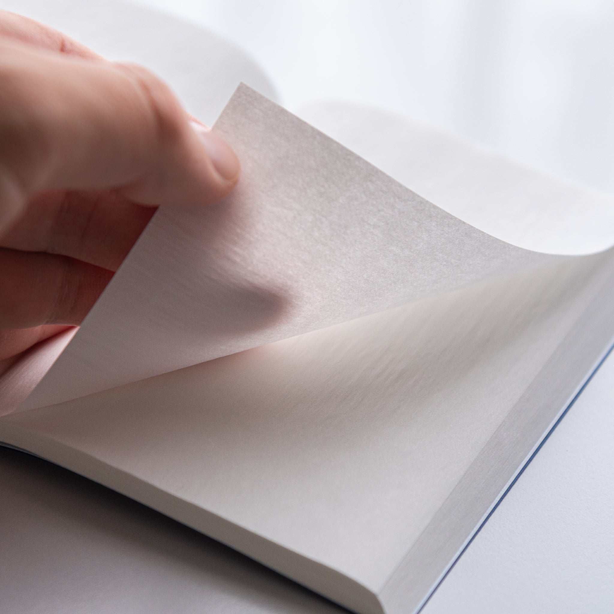 Detail close-up of Dressco Onion Skin Paper A6 notebook fourth variant showing semi-transparent paper and cover edge