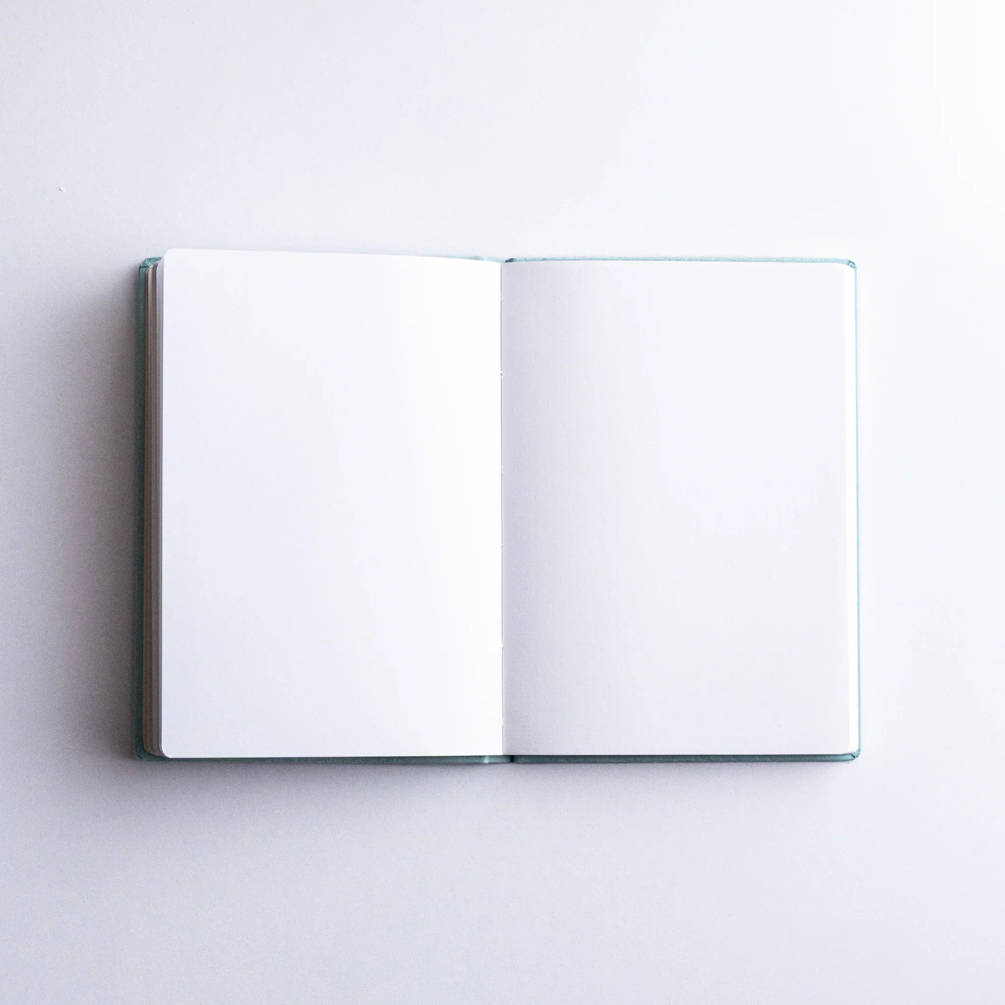 Dressco Spica Laid Bond Paper A6 notebook shown at an angle revealing the cover texture and bound spine detail