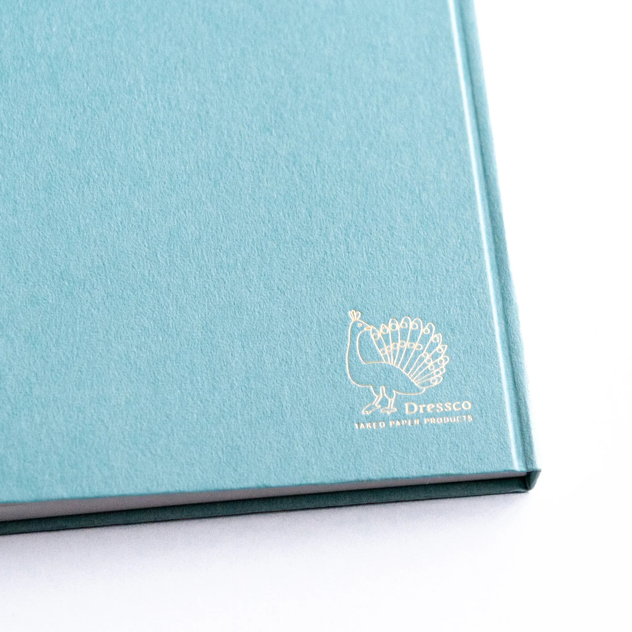 Close-up of gold embossed logo on Dressco Spica Laid Bond Paper Japanese Notebook in Willow Green.