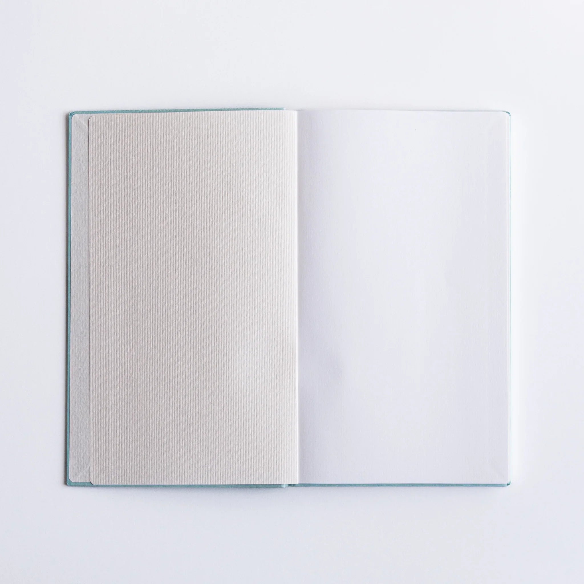 Open pages of Dressco Spica Laid Bond Japanese Notebook B6 with smooth white paper.