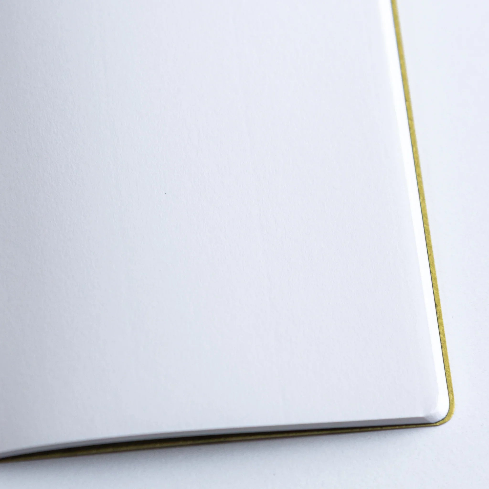 Side profile of Dressco Spica Laid Bond Stitched A6 notebook showing the book thickness and stitched spine detail