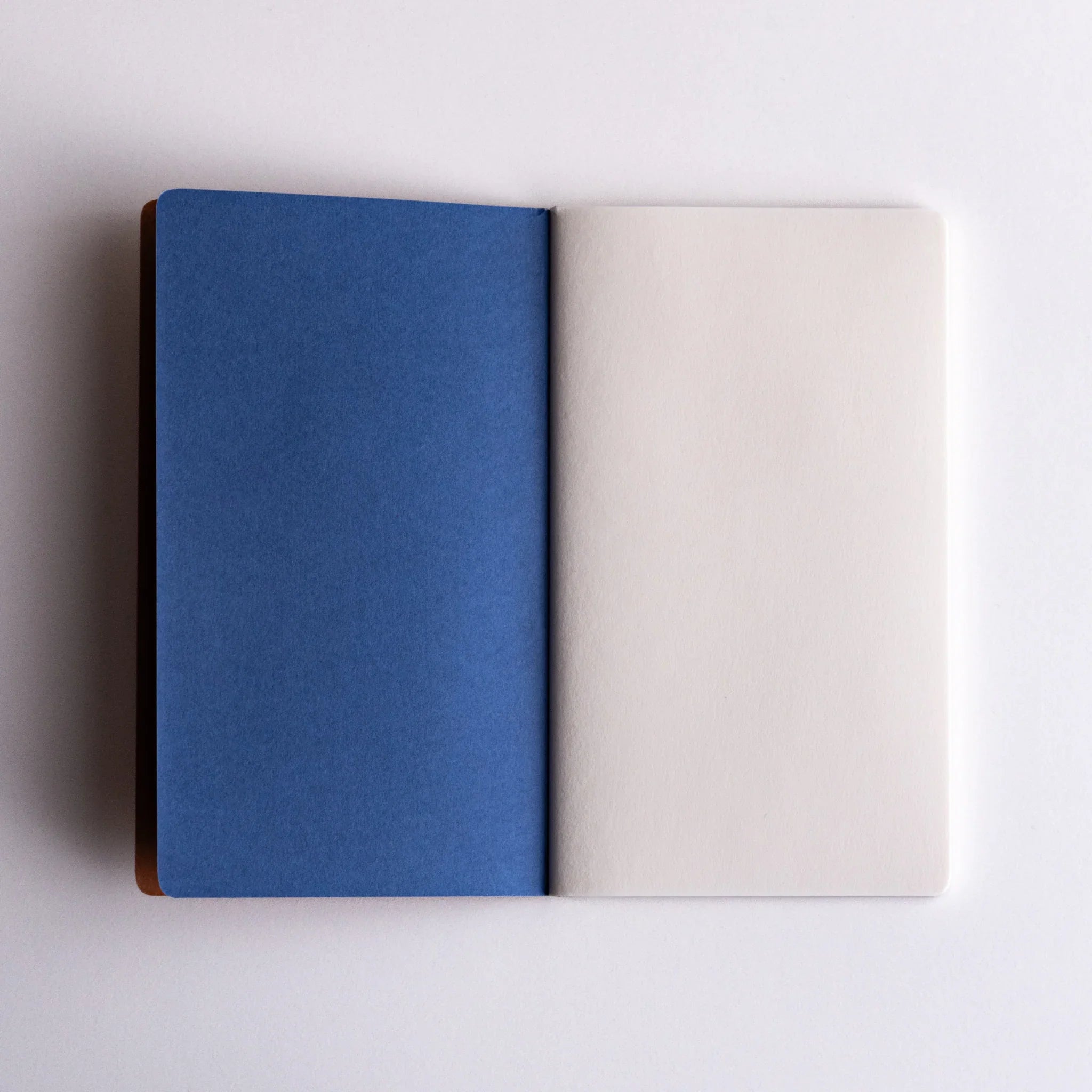 Open Japanese notebook made from Bank Ledger Paper showing blue cover page and white first page.