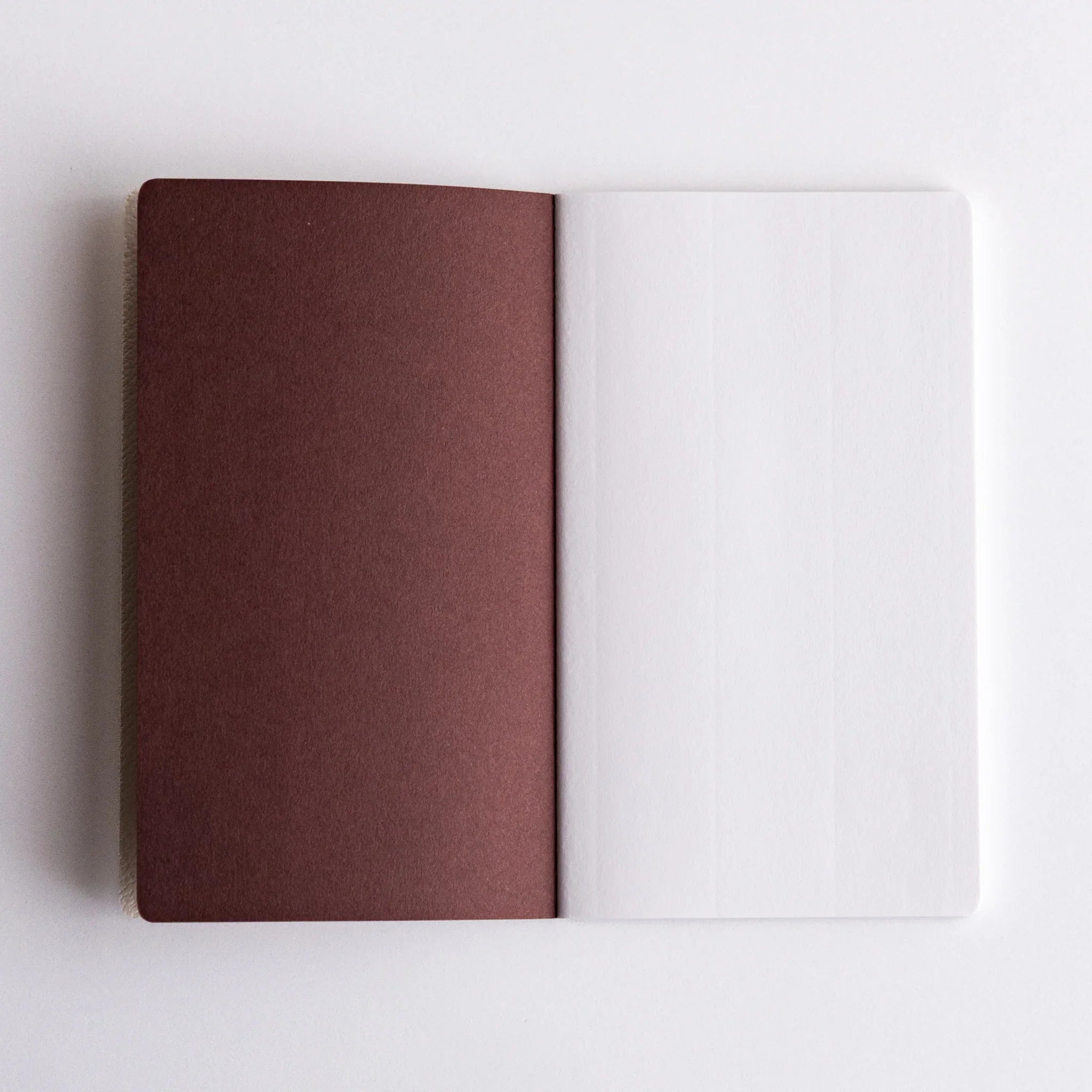 Open Japanese notebooks made from Spica Laid Bond Paper (white), highlighting contrasting cover and page textures.