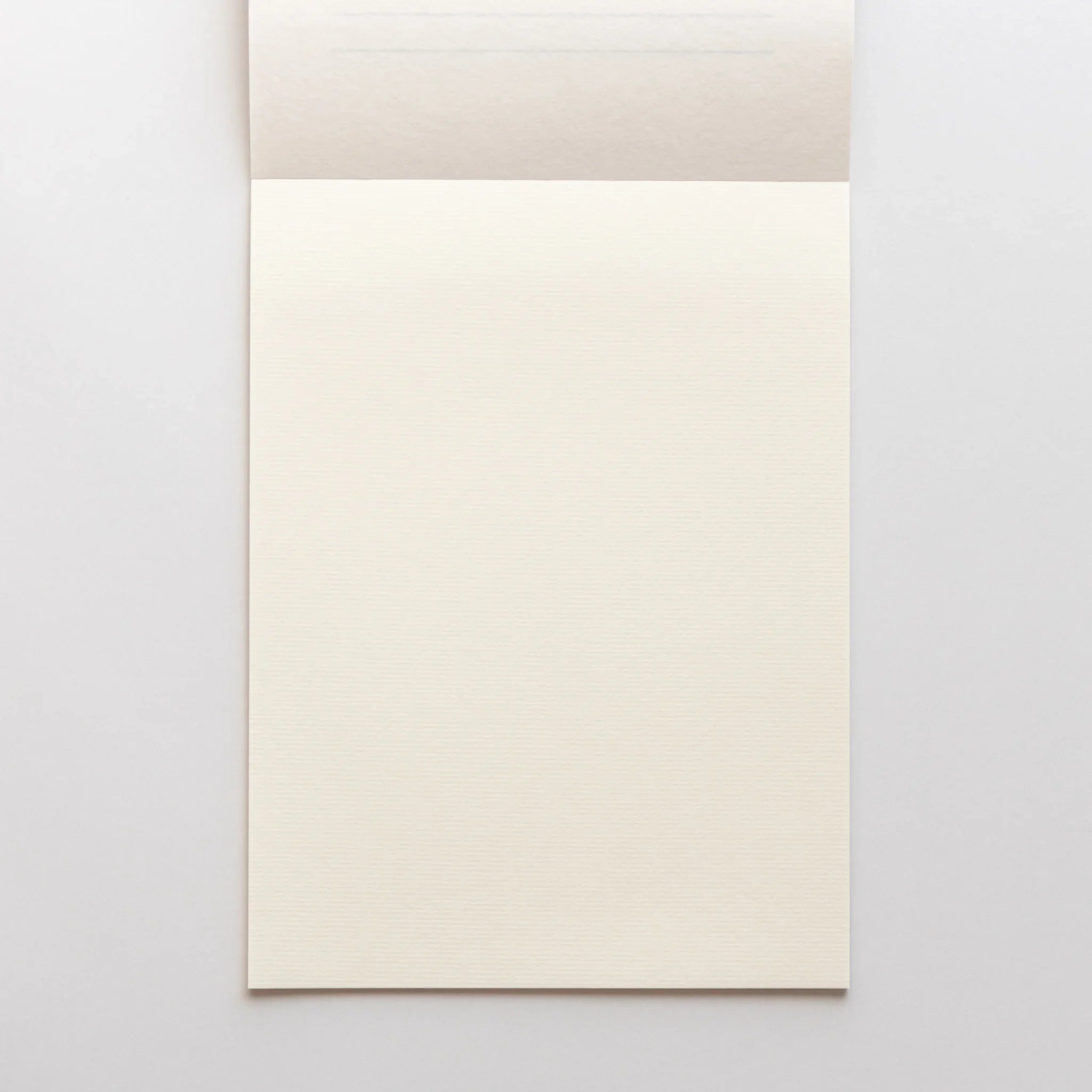 Angled view of Strathmore pad showing soft fold and cream pages with clearly visible paper grain texture