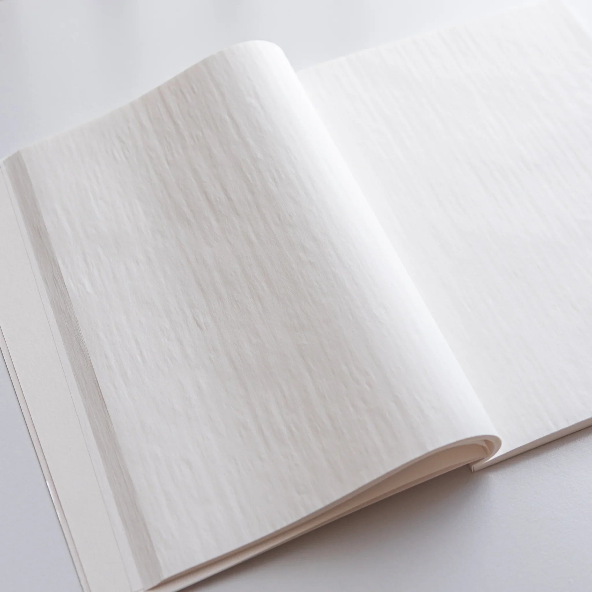White paper pages layered and fanned showing thin translucent Onion Skin paper quality and texture shown