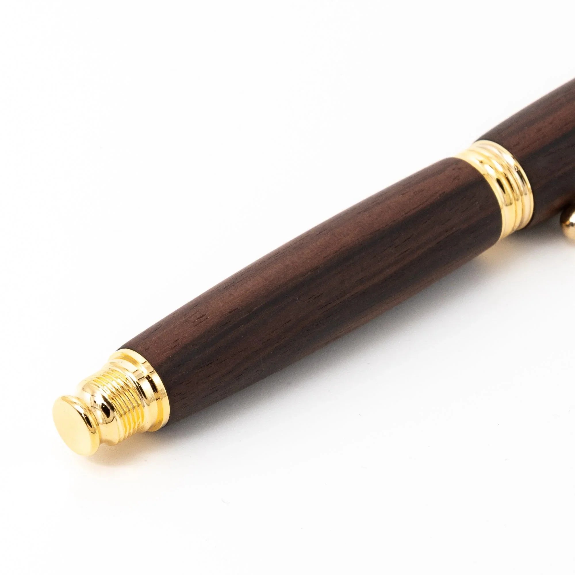 Side view of dark wood fountain pen with gold ring band and writing nib detail clearly visible displayed clearly