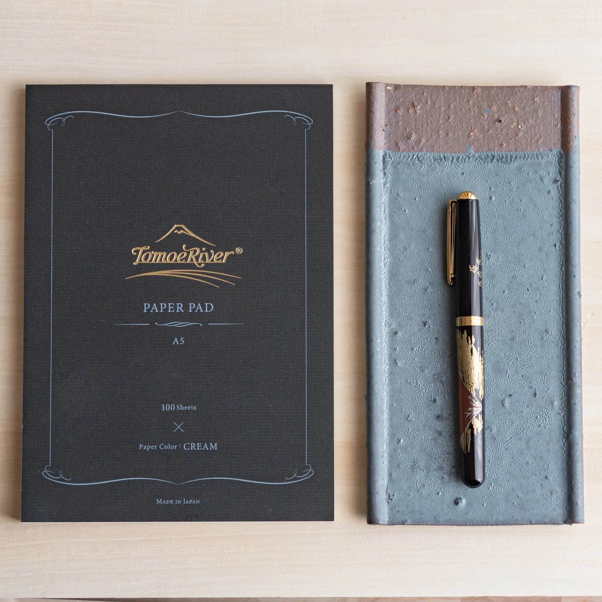 Japanese Pen Tray Desk Accessory with silver gray ceramic tray beside a Tomoe River paper pad, holding a fountain pen.