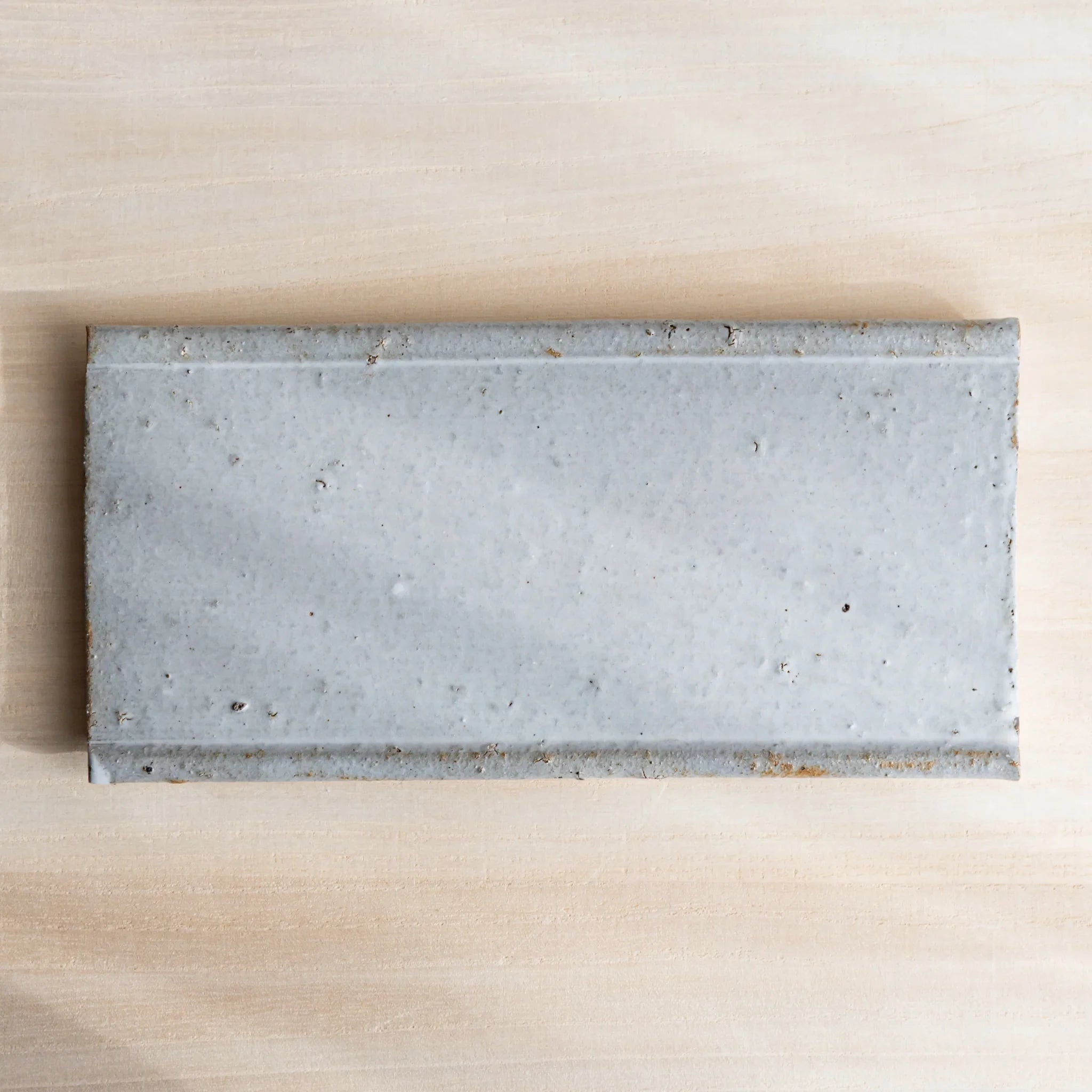 Japanese Pen Tray Desk Accessory top view of white glaze ceramic tray on light wooden desk.
