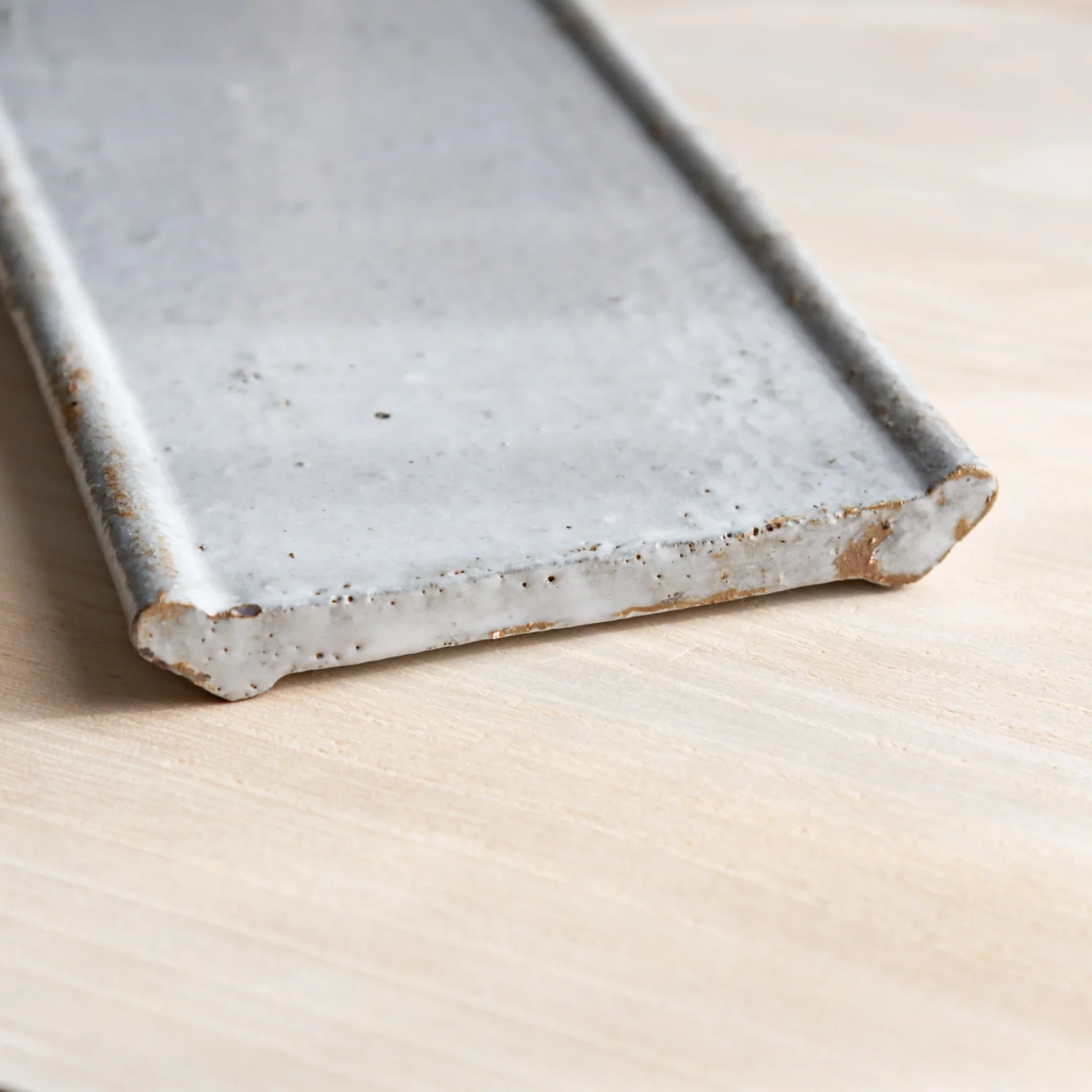 Japanese Pen Tray Desk Accessory showcasing side view of white glaze ceramic tray on wooden desk.