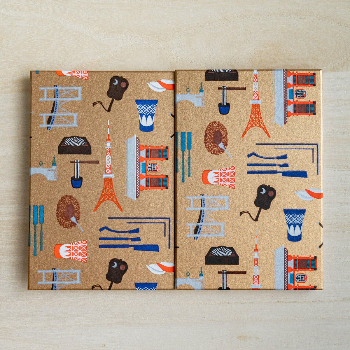 Edo Tokyo goshuincho stamp book opened out flat, both gold covers printed with Tokyo Tower, Skytree and food motifs