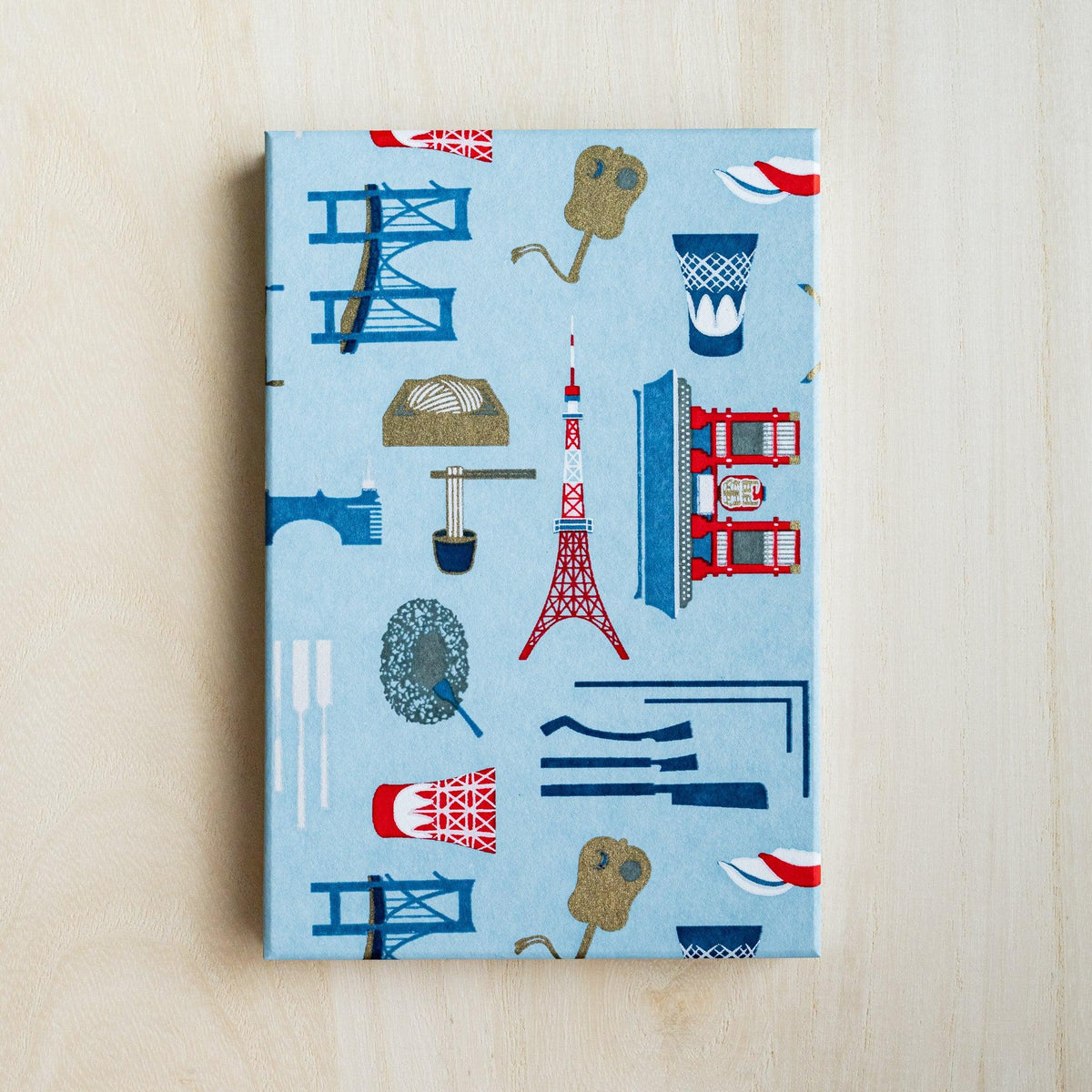 Full light blue cover of Edo Tokyo goshuincho stamp book with Tokyo Tower, bridges, sushi and cup motifs