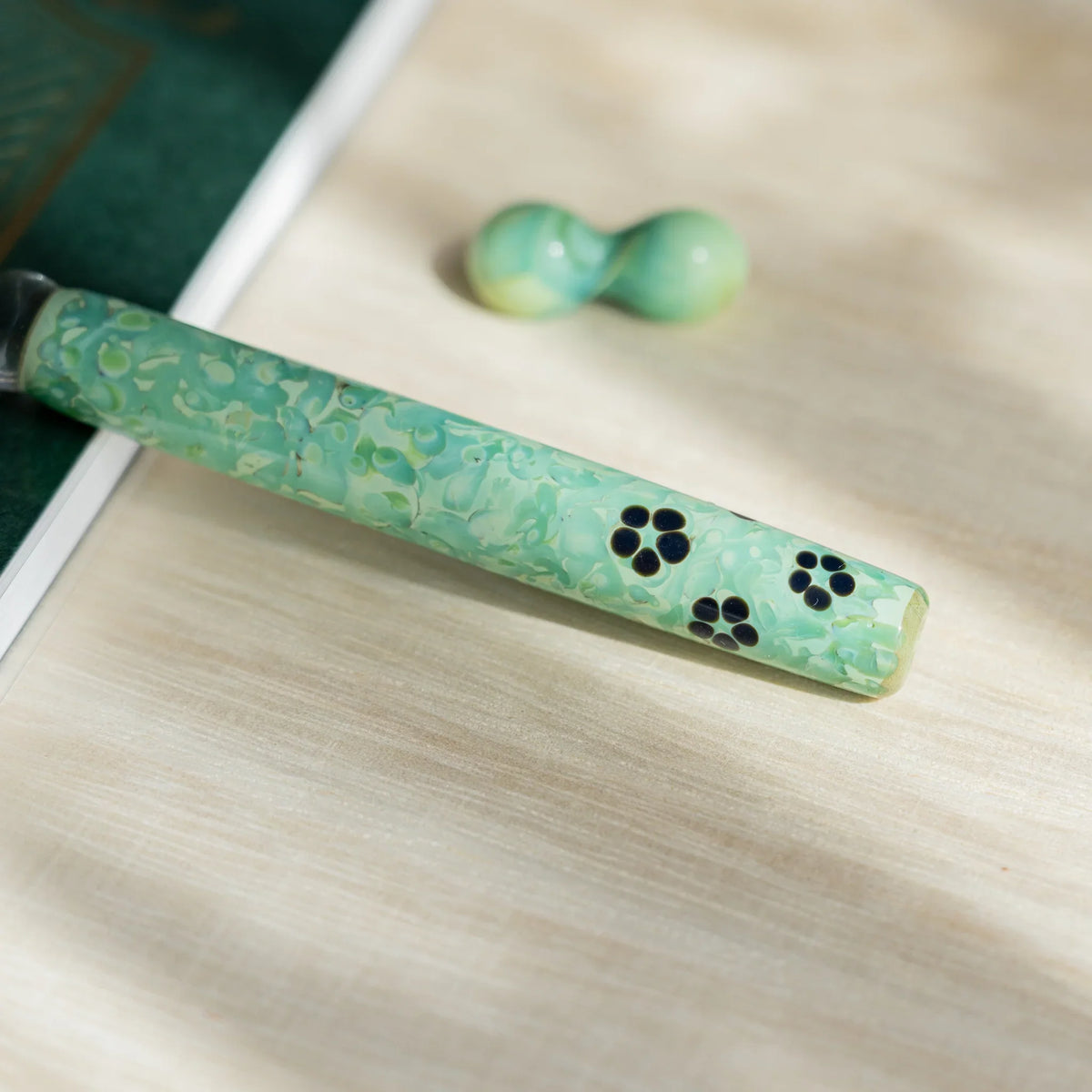 Close-up of the green marbled barrel scattered with dark five-petal blossom motifs