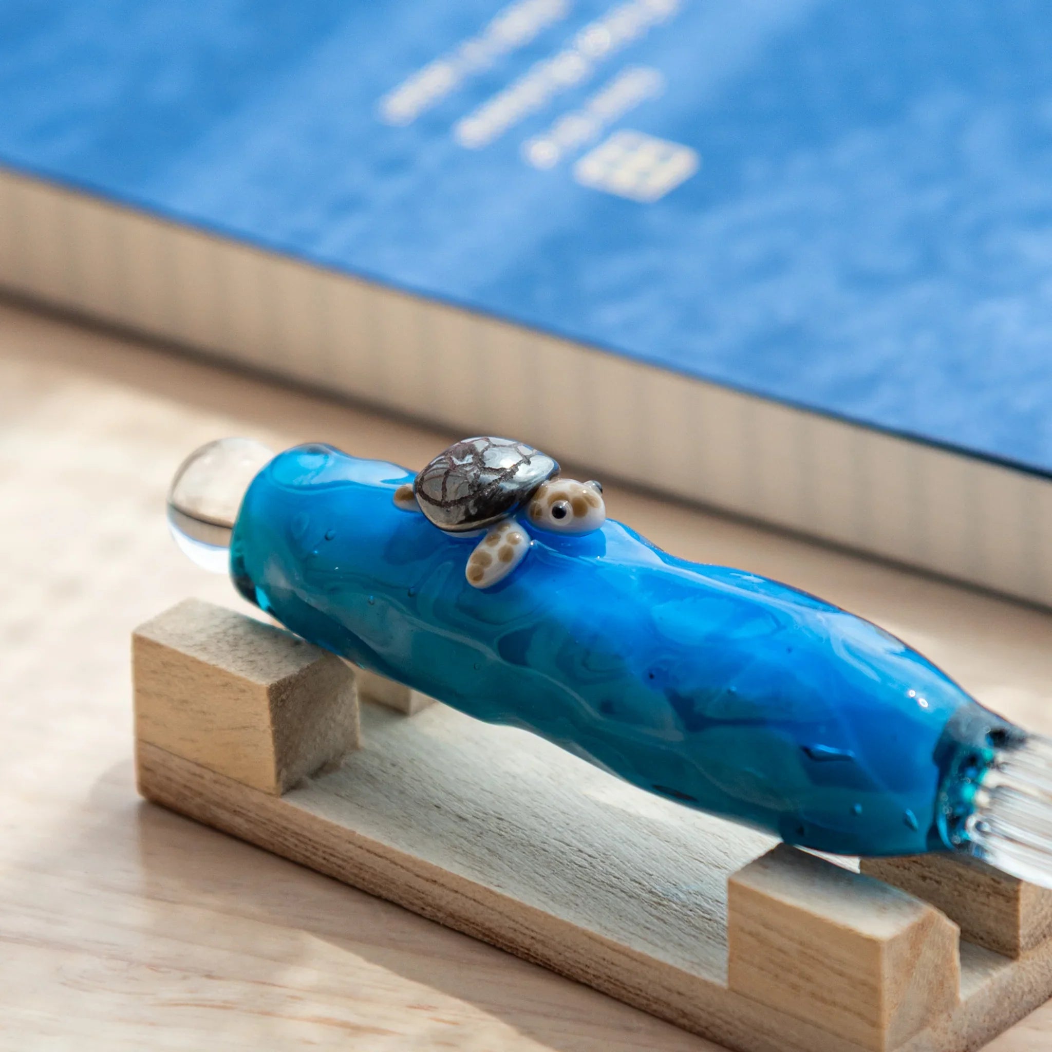 Floating turtle glass dip pen with enclosed decorative figure visible inside transparent barrel, detailed Japanese craft