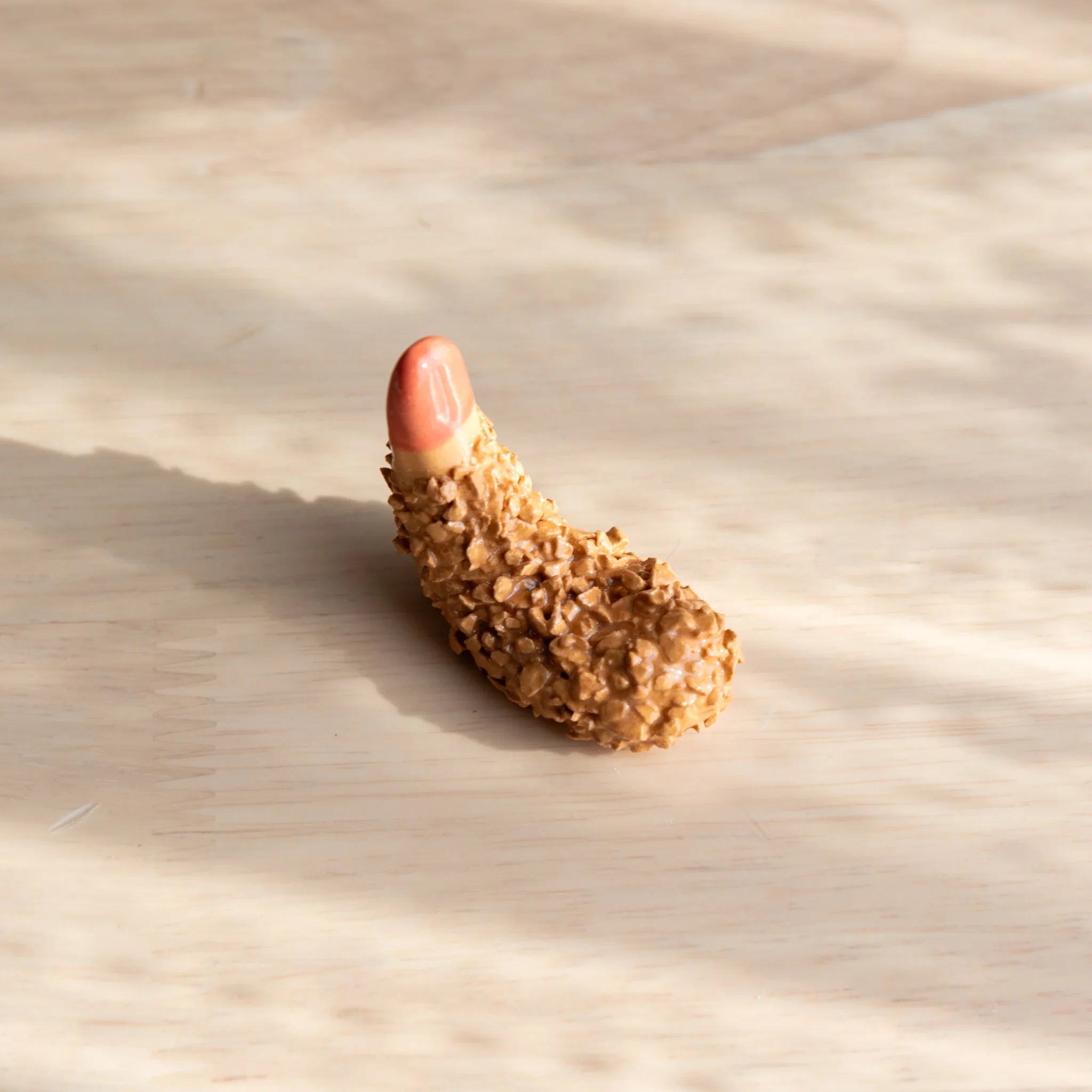 Orange fried shrimp handcrafted pen rest with curved crustacean shape showing detailed food-like textured surface design