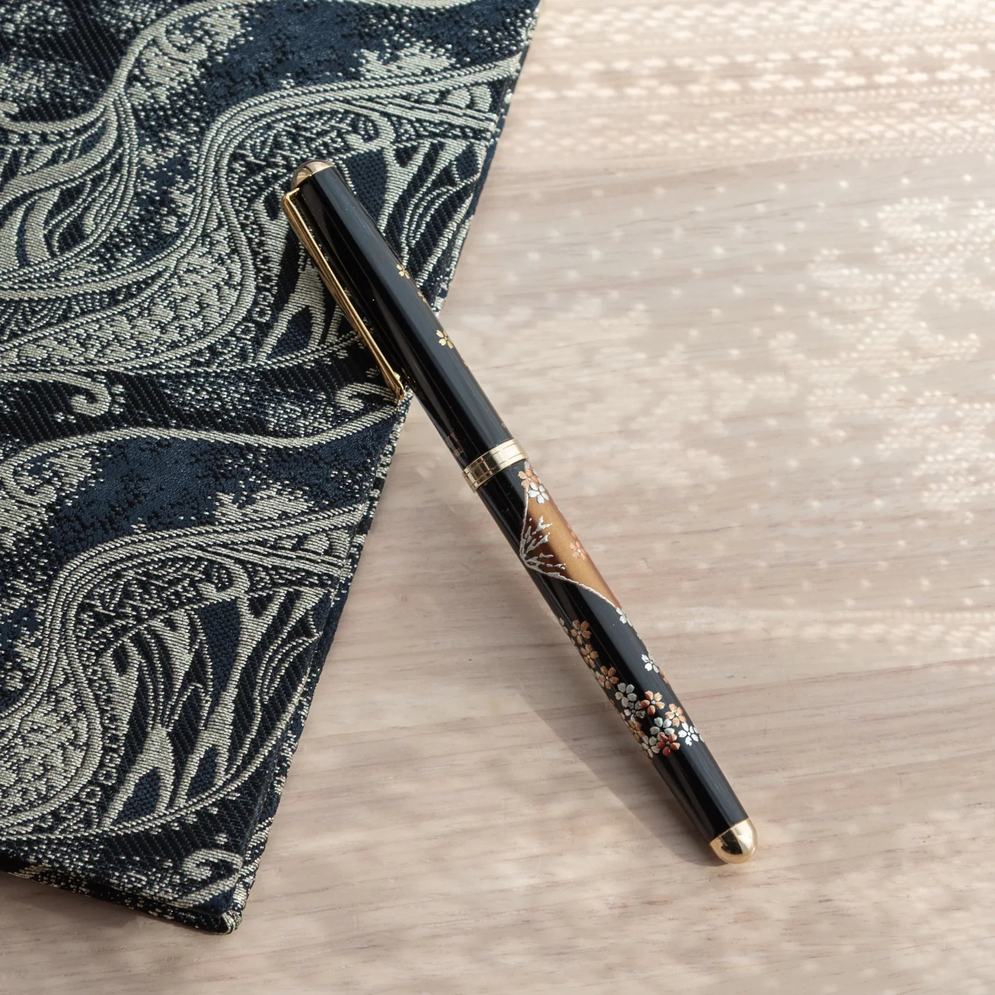 Yamanaka lacquer ballpoint pen displays hand-painted fuji and sakura in warm lacquer finish tones for writing