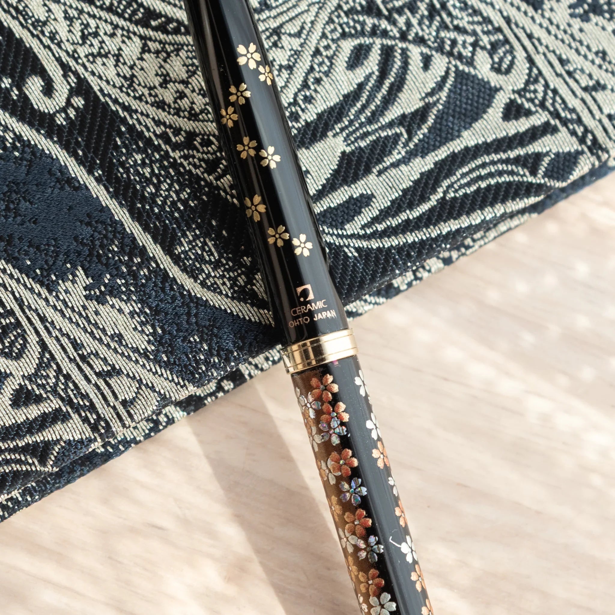 Red lacquer Yamanaka ballpoint pen features detailed Mount Fuji and cherry blossom landscape painting