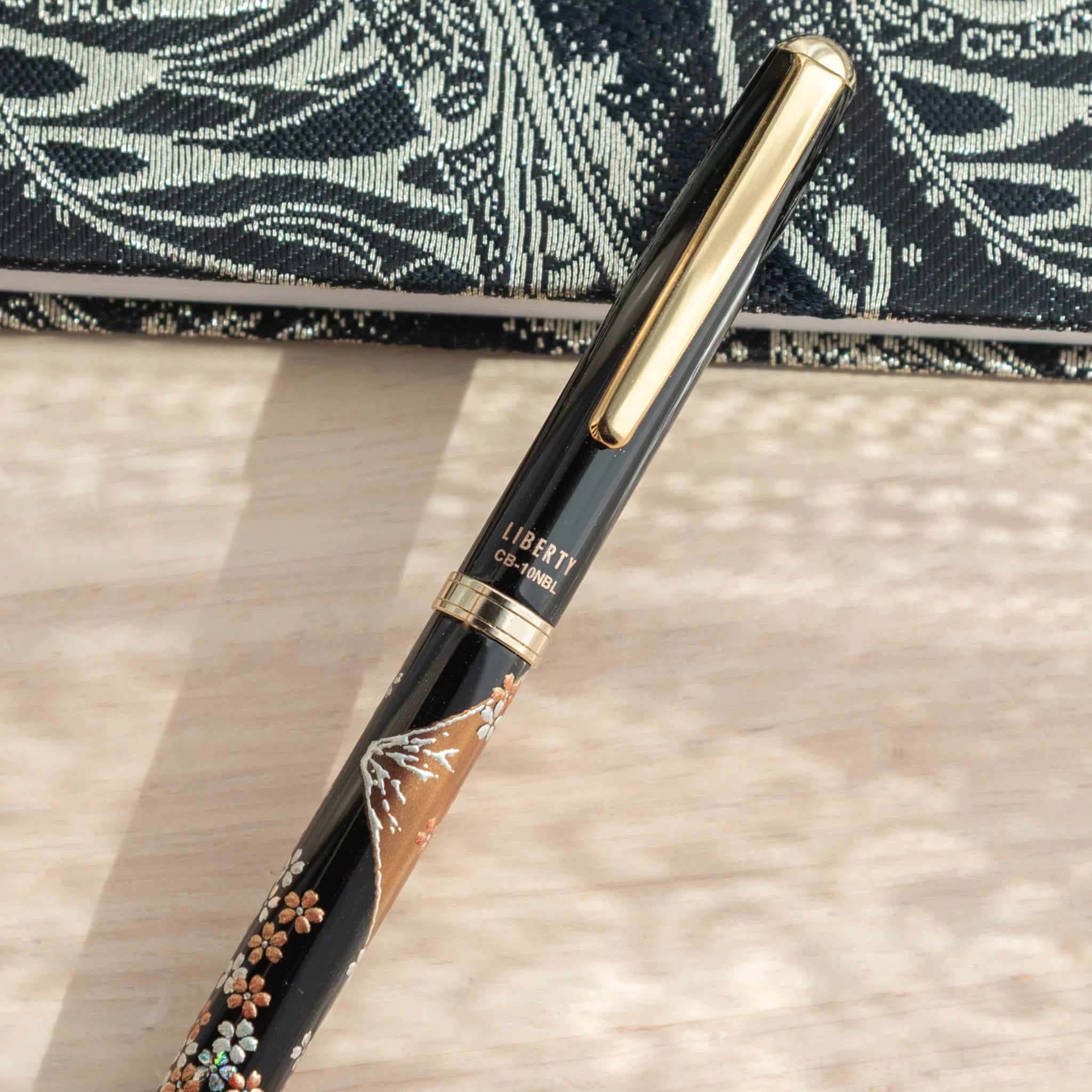 Japanese Ballpoint Pen with Lacquer sakura blossoms and Mt. Fuji details, golden trim, and LIBERTY branding.