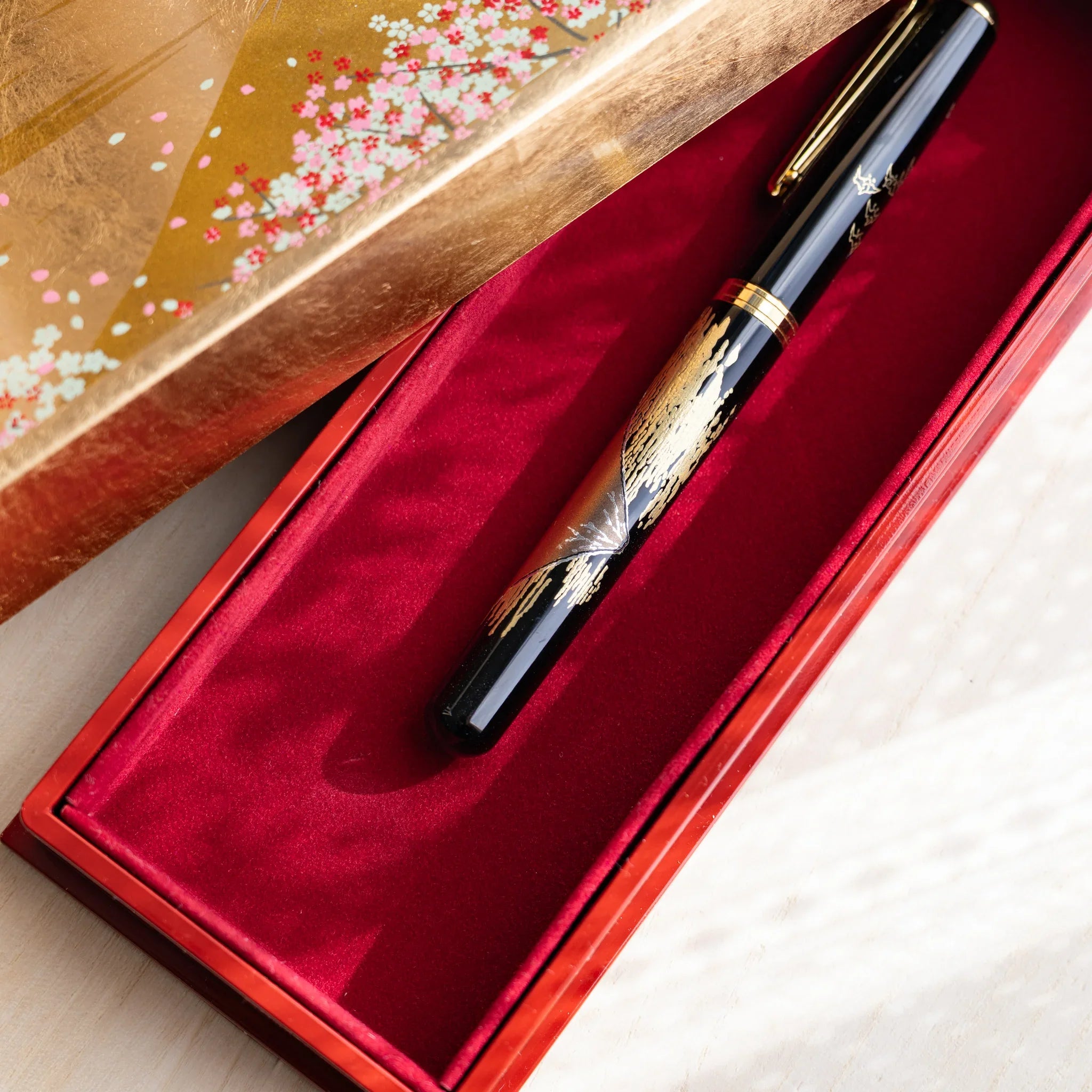 Elegant Japanese pen case with red velvet interior, lacquered pen and cherry blossom lid design from Japan