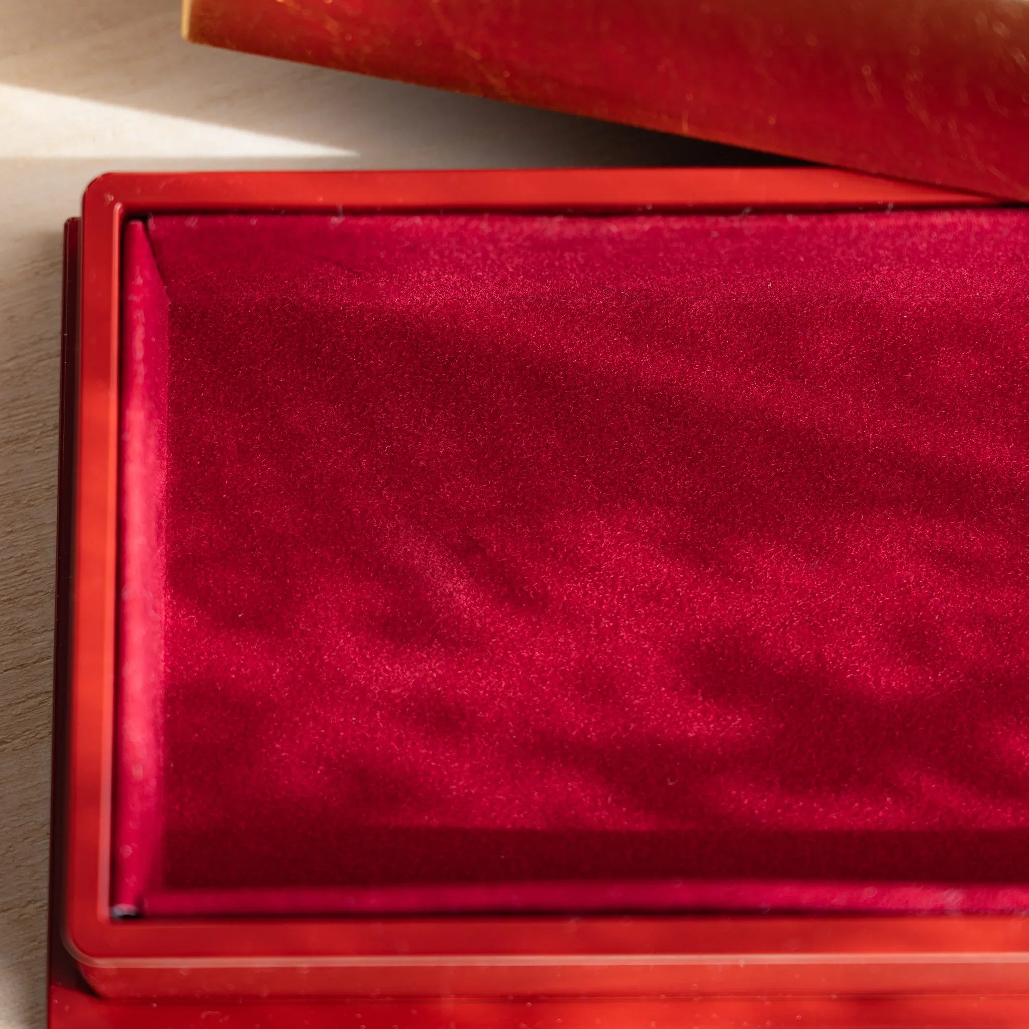 Close-up of plush red felt interior of a Japanese pen case, showing texture and protective lining for pens