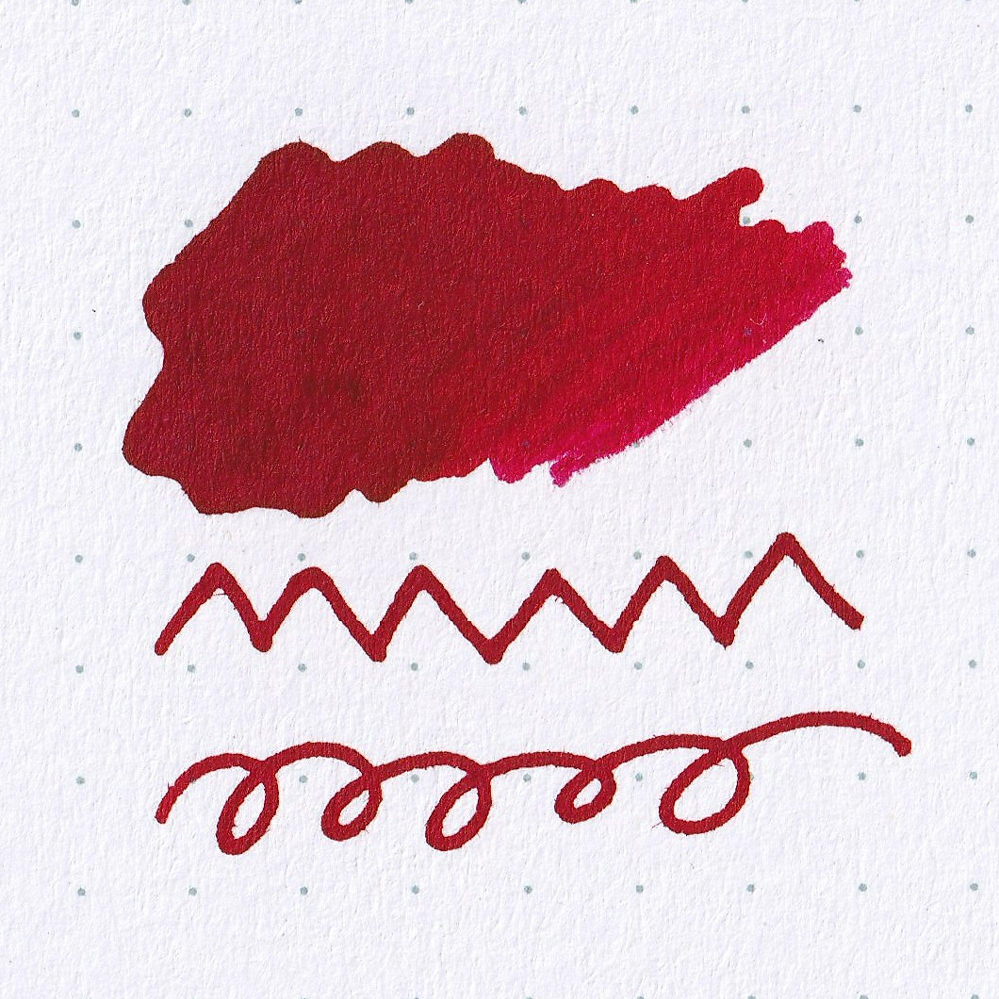 Close-up of Fujiyama Irodori Akane ink bottle, highlighting its striking red ink and minimalist label design on a wooden surface.