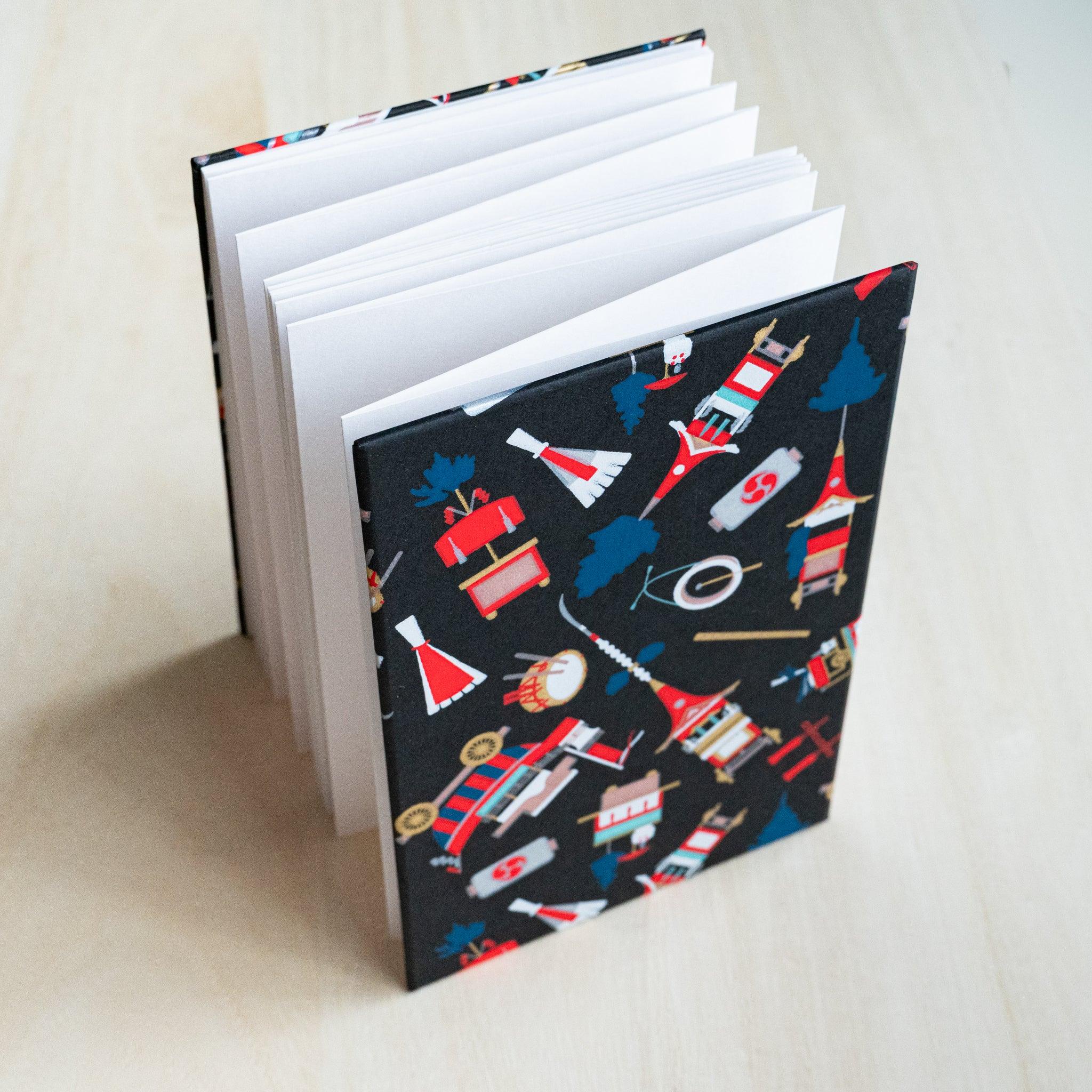 Gion Kyoto goshuincho stamp book standing open, accordion-fold white pages fanned out, black cover
