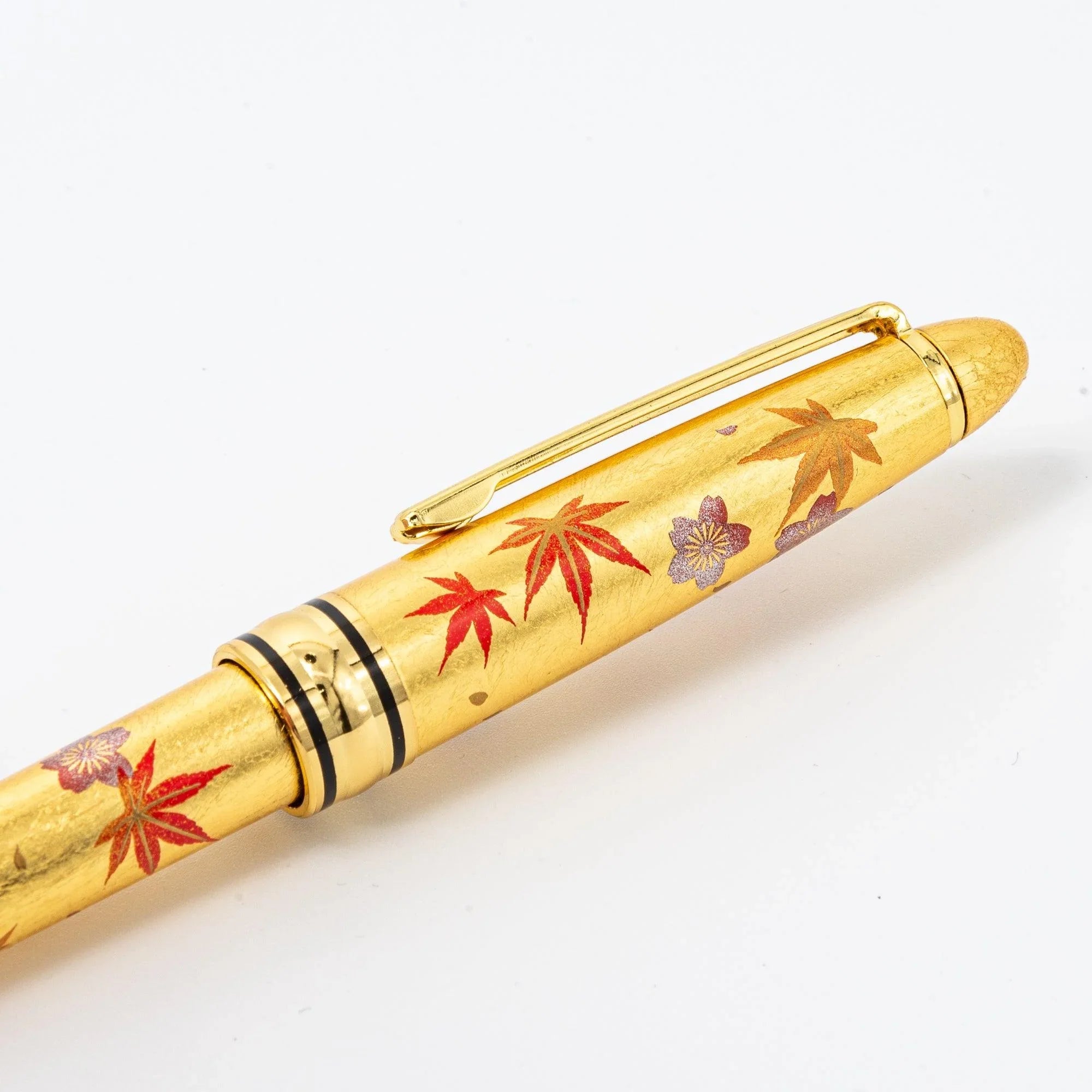 Close-up view Gold Leaf Sakura and Momiji ballpoint pen with spring sakura and autumn momiji in gold makie