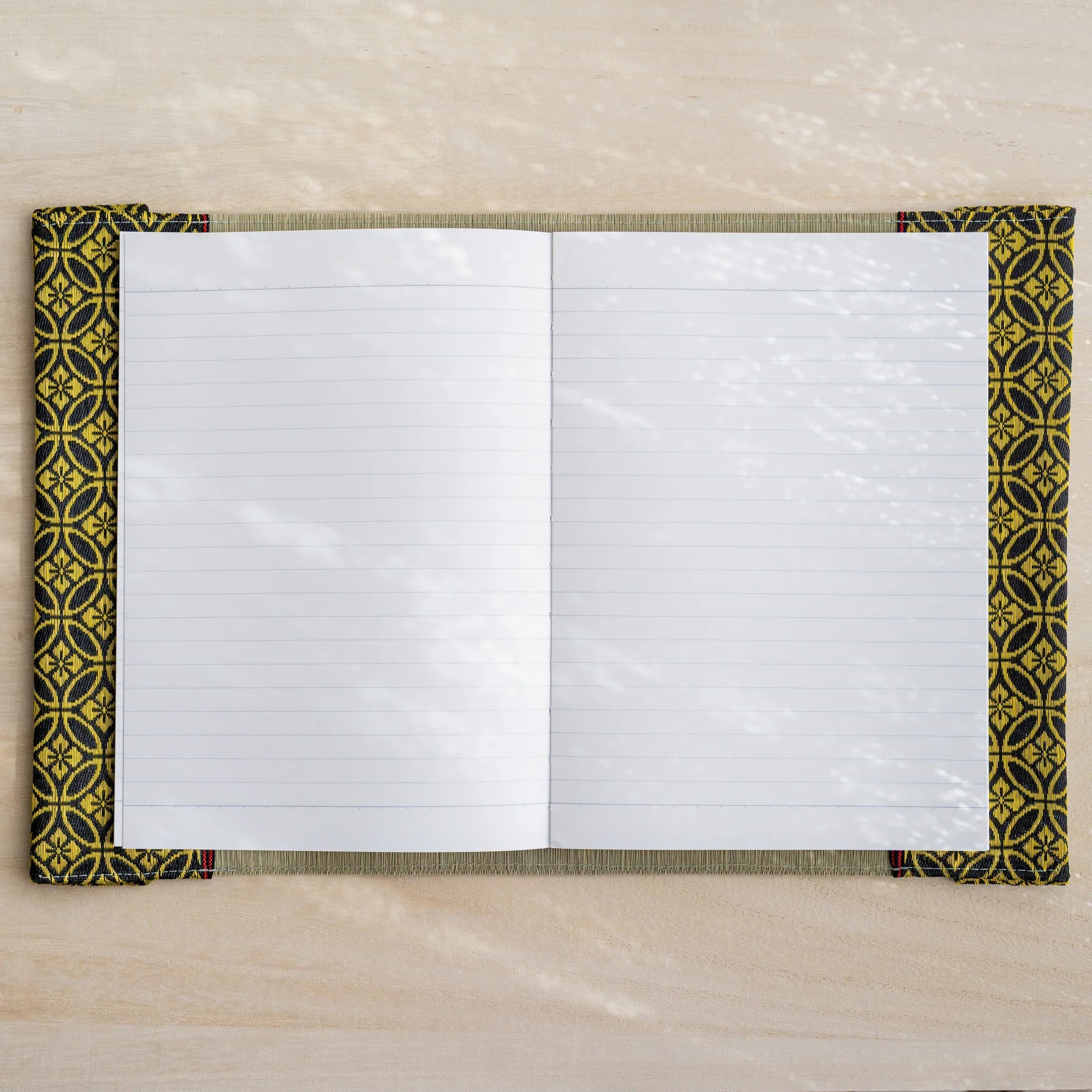 Gold Shippo tatami book cover open flat with white lined notebook pages, black and gold Japanese pattern edges
