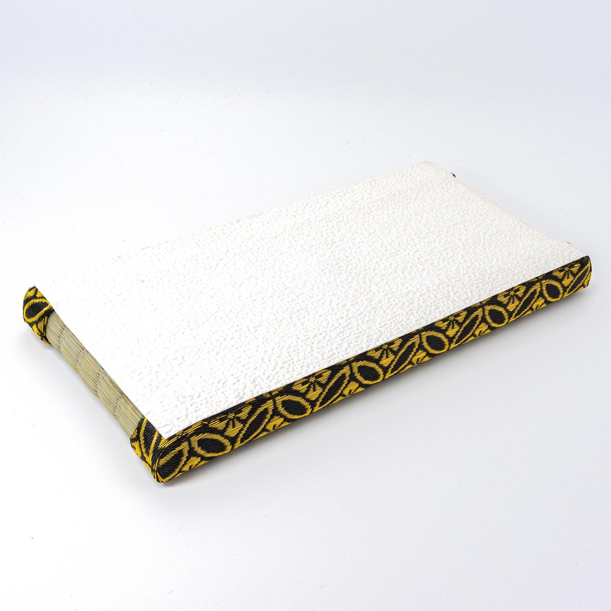 Reverse side of a Japanese tatami pen tray, showcasing its textured white bottom and red floral-patterned fabric edges, displayed on a plain background.