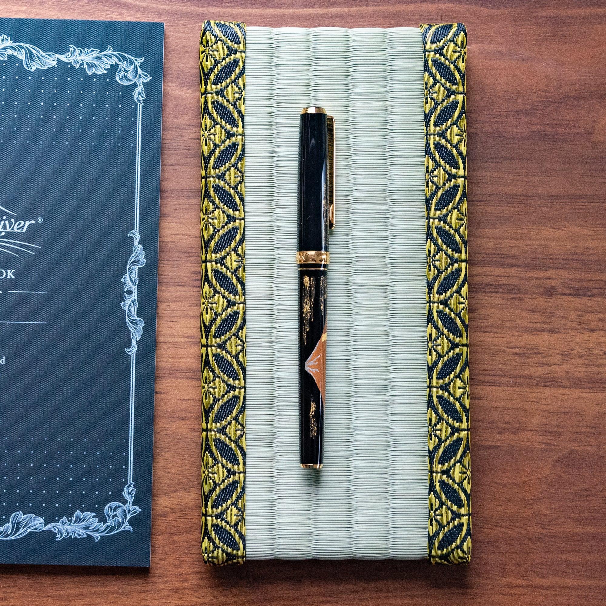 Top view of tatami mat pen holder with decorative gold brocade shippo pattern borders on both sides clearly
