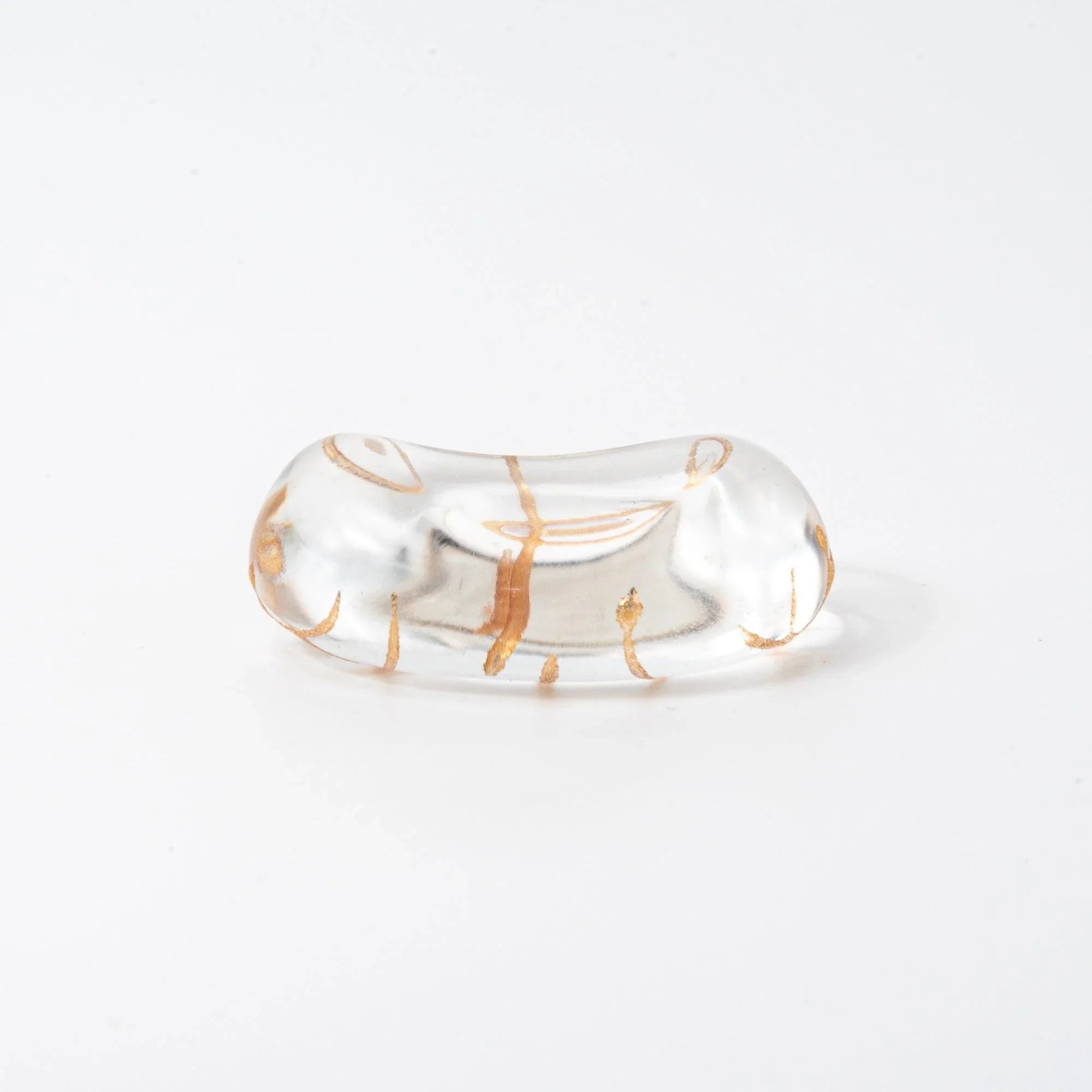 Japanese transparent glass pen rest with wavy gold thread motif and organic flowing curved pattern inside, side angle