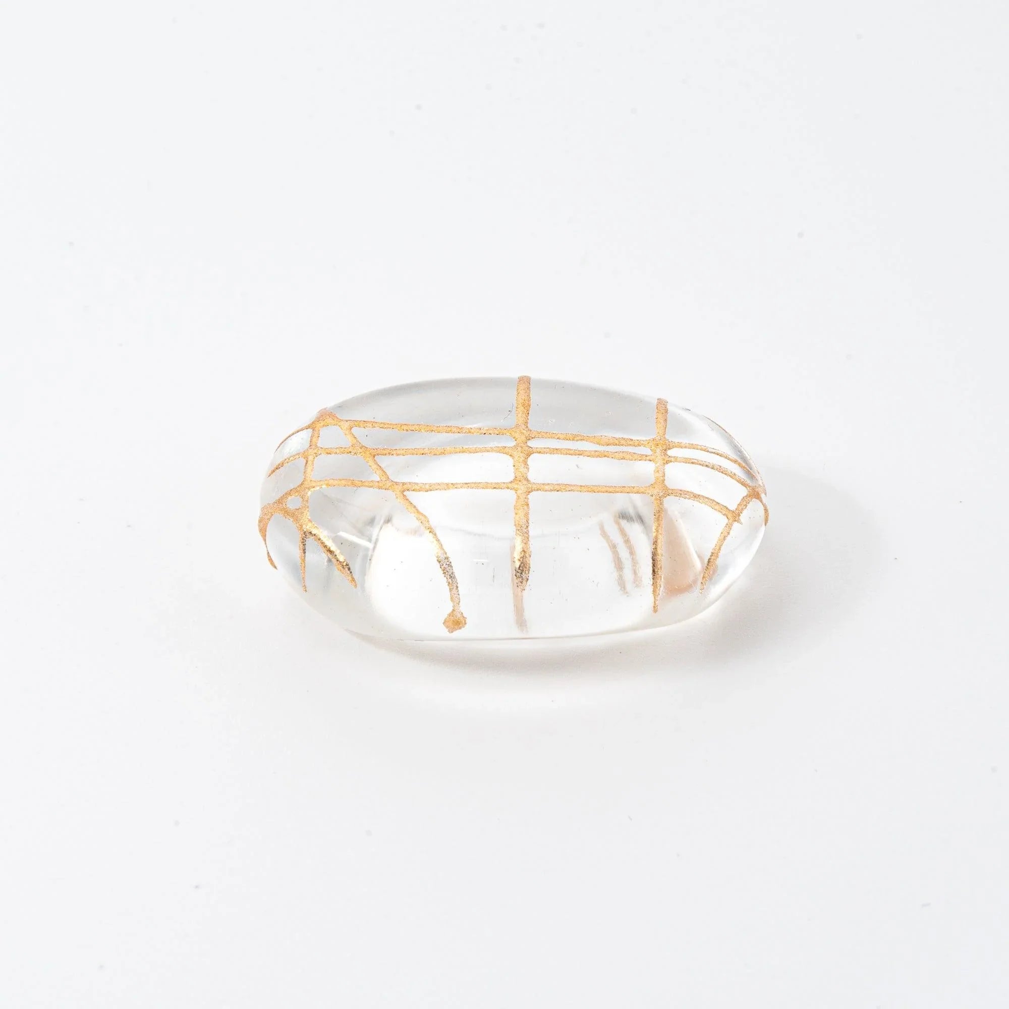 Japanese oval glass pen rest featuring gold thread interior lattice pattern visible from three-quarter viewing angle