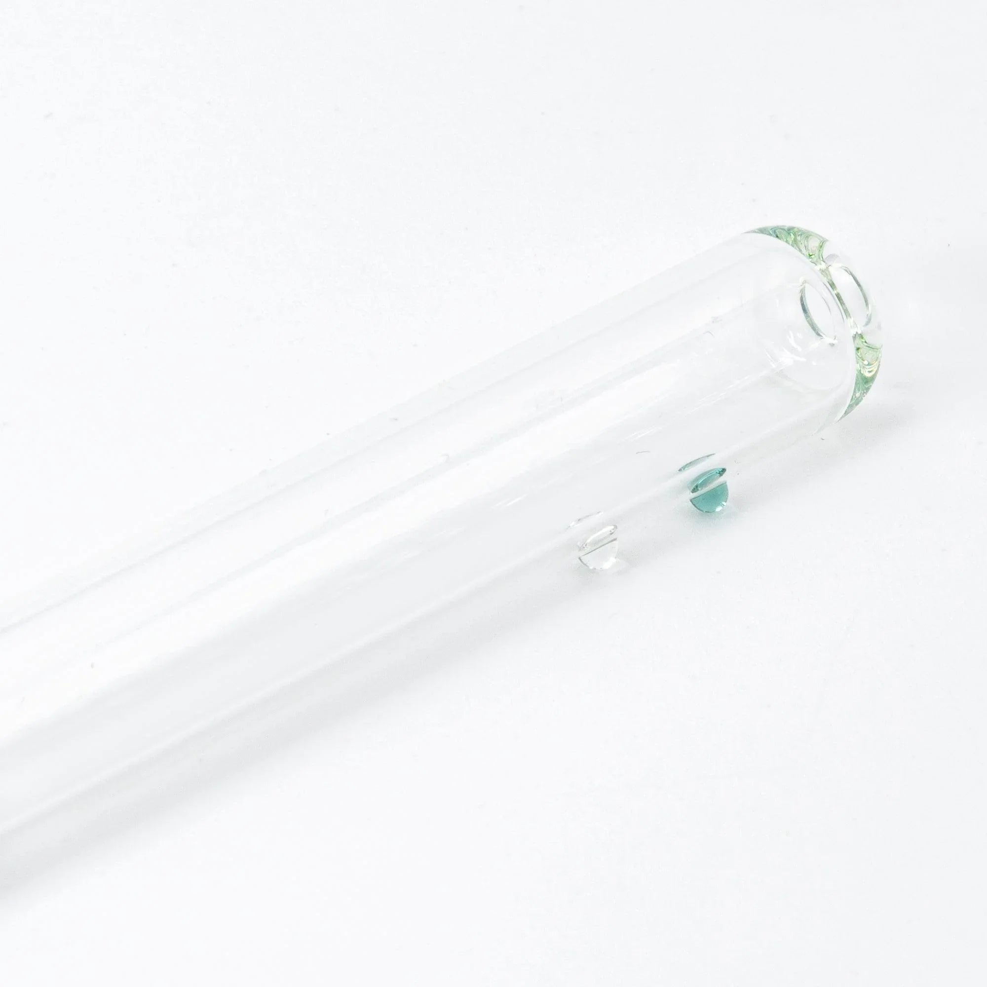 Angled top view of green glass candy-filled dip pen with captured decorative inclusions and twisted nib with holder