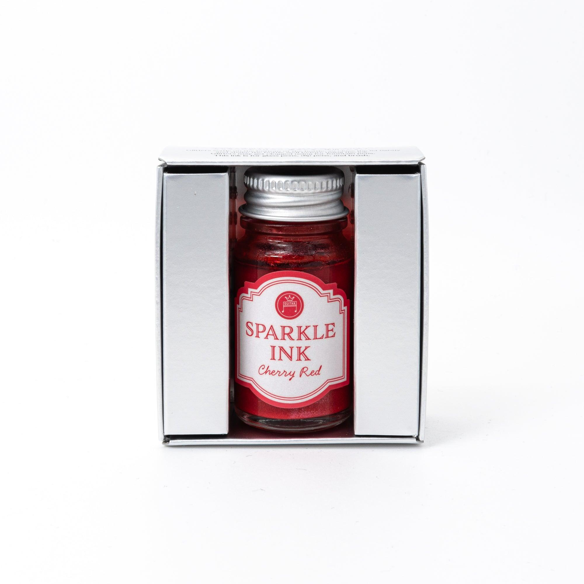 A bottle of Sparkle Ink in Cherry Red, accompanied by its matching red decorative box, adorned with intricate floral patterns.
