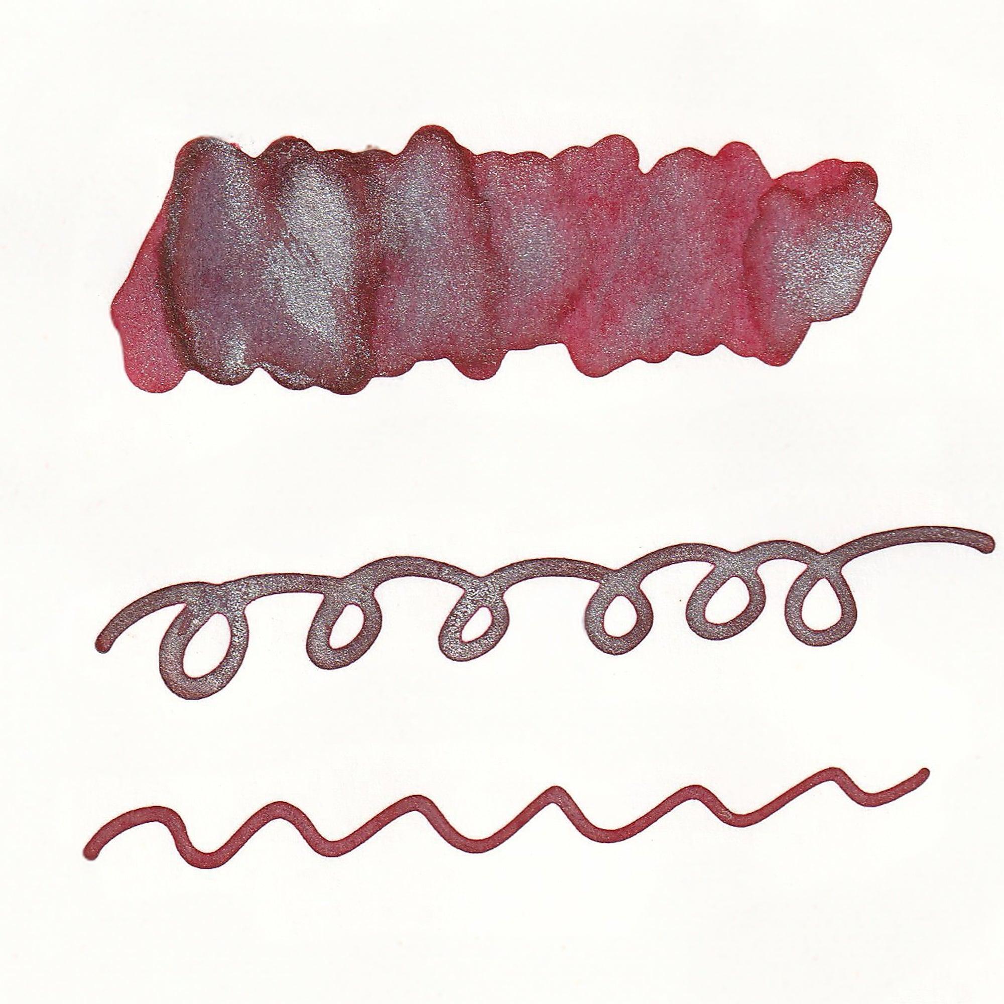 Swatches of Sparkle Ink in Crimson Red, showcasing deep red tones with shimmering effects, displayed as solid and line patterns on white paper.