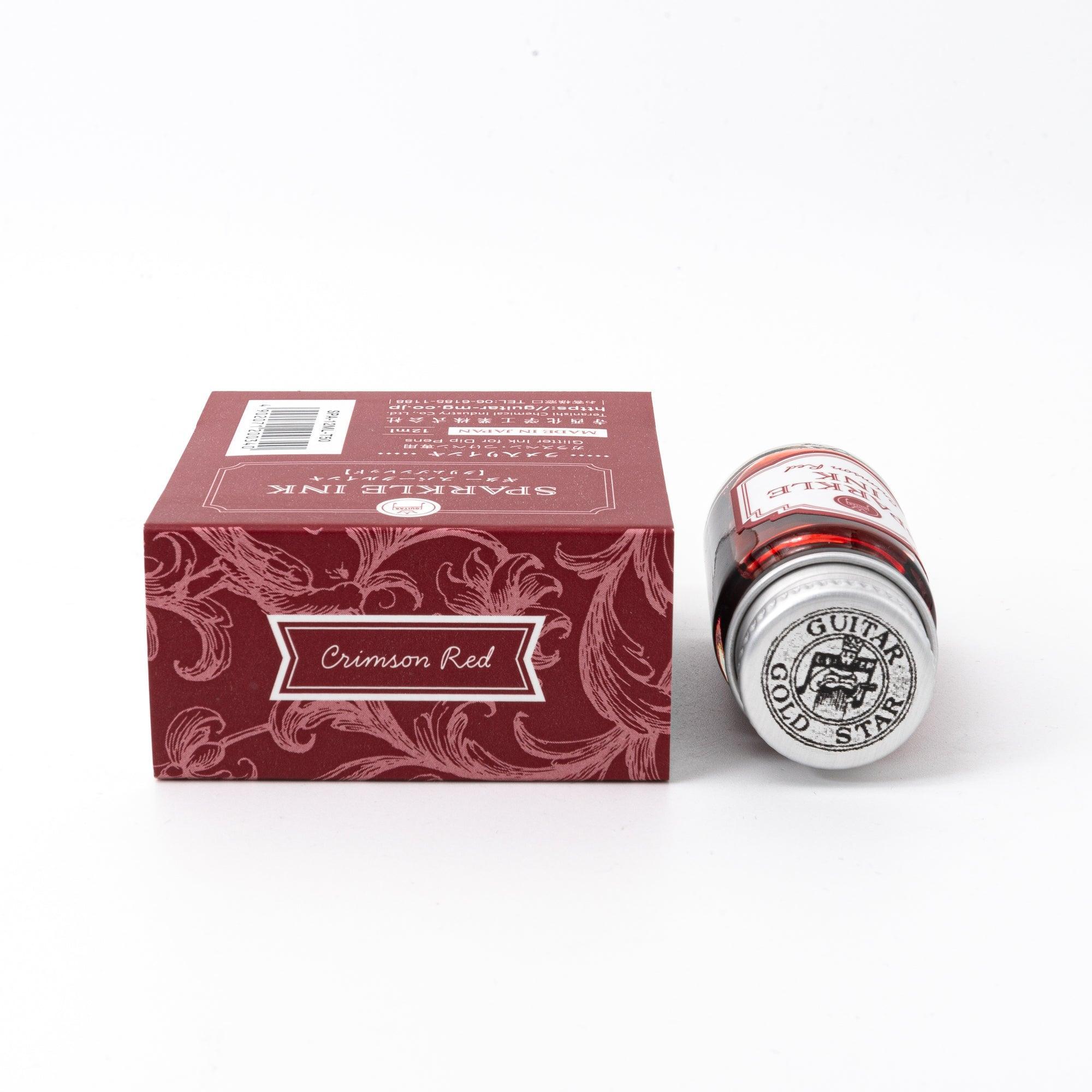 Sparkle Ink in Crimson Red, presented in a glass bottle with matching red packaging adorned with intricate floral patterns and elegant text.