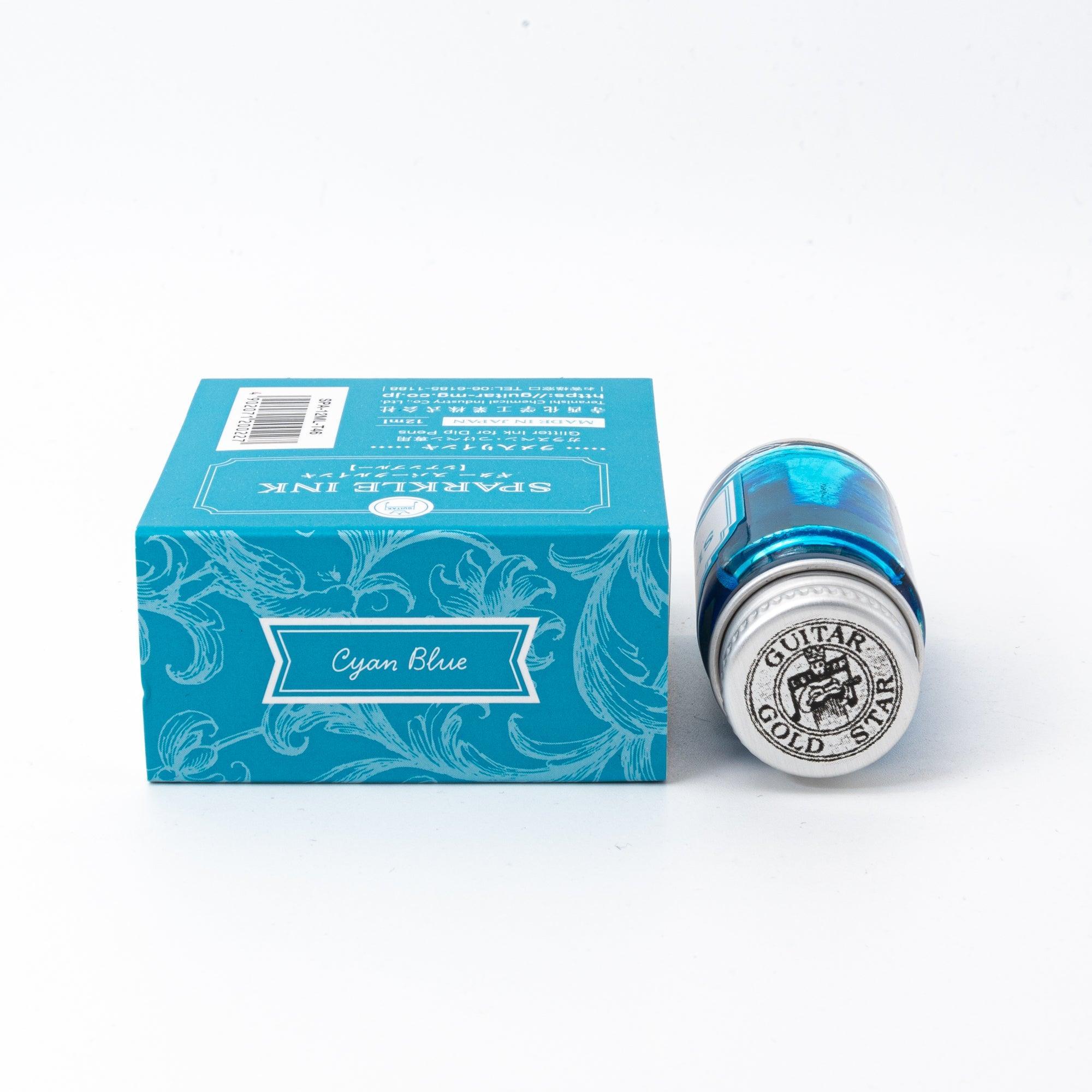 Sparkle Ink in Cyan Blue, displayed in a glass bottle with matching cyan packaging featuring floral patterns and elegant lettering.