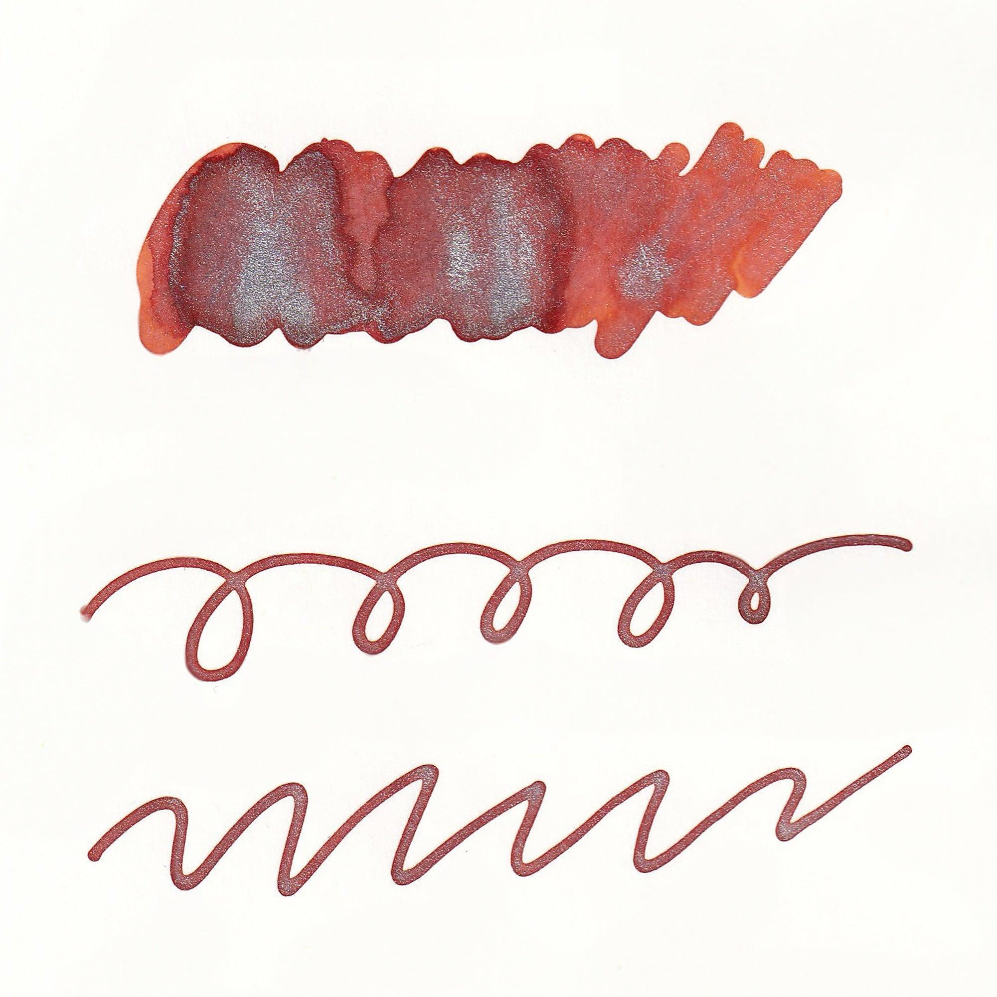 Swatches of Sparkle Ink in Ginger Orange, showing vibrant orange tones with shimmering highlights on white paper, including lines and a solid stroke.