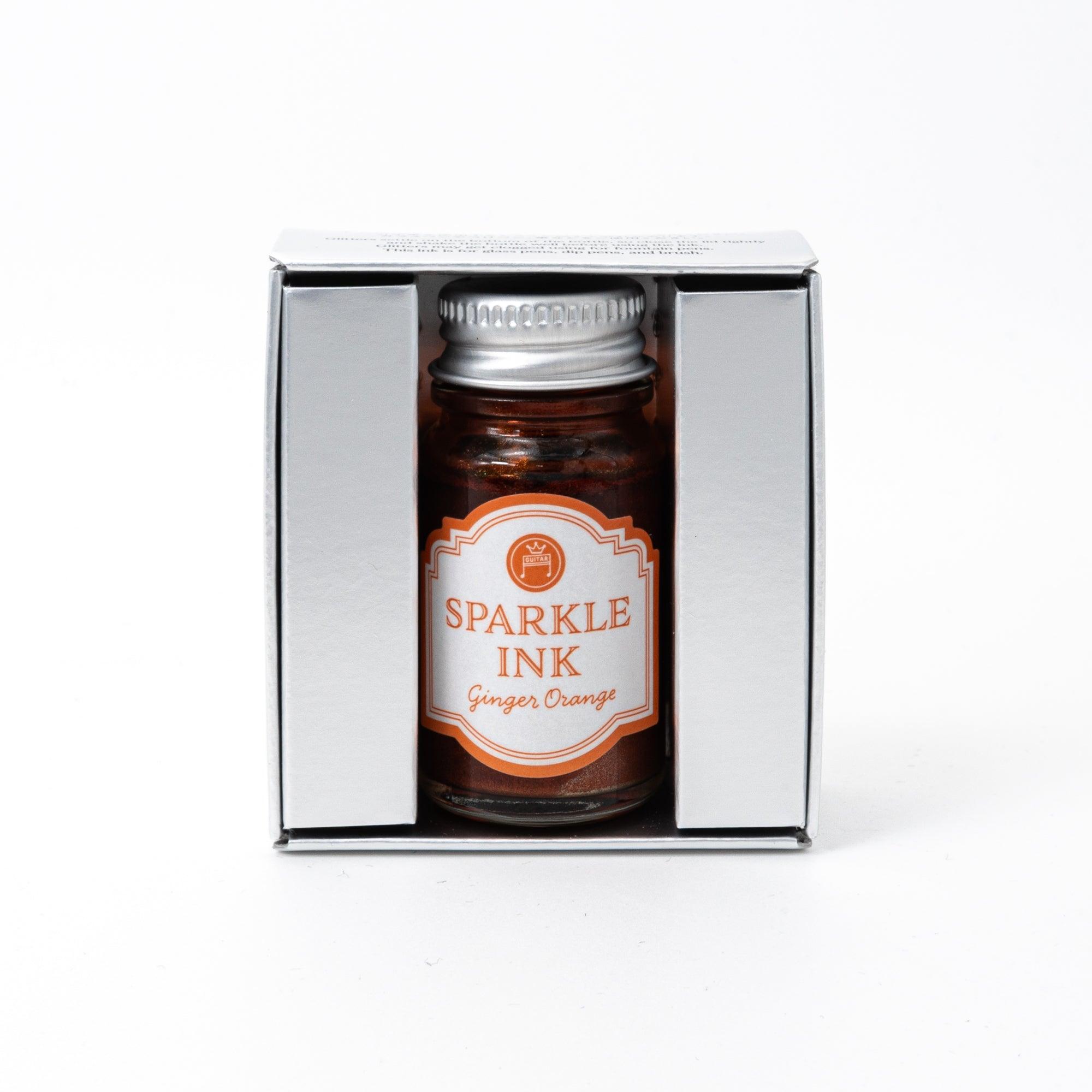 Sparkle Ink in Ginger Orange, displayed in a glass bottle with matching orange packaging featuring floral patterns and elegant lettering.