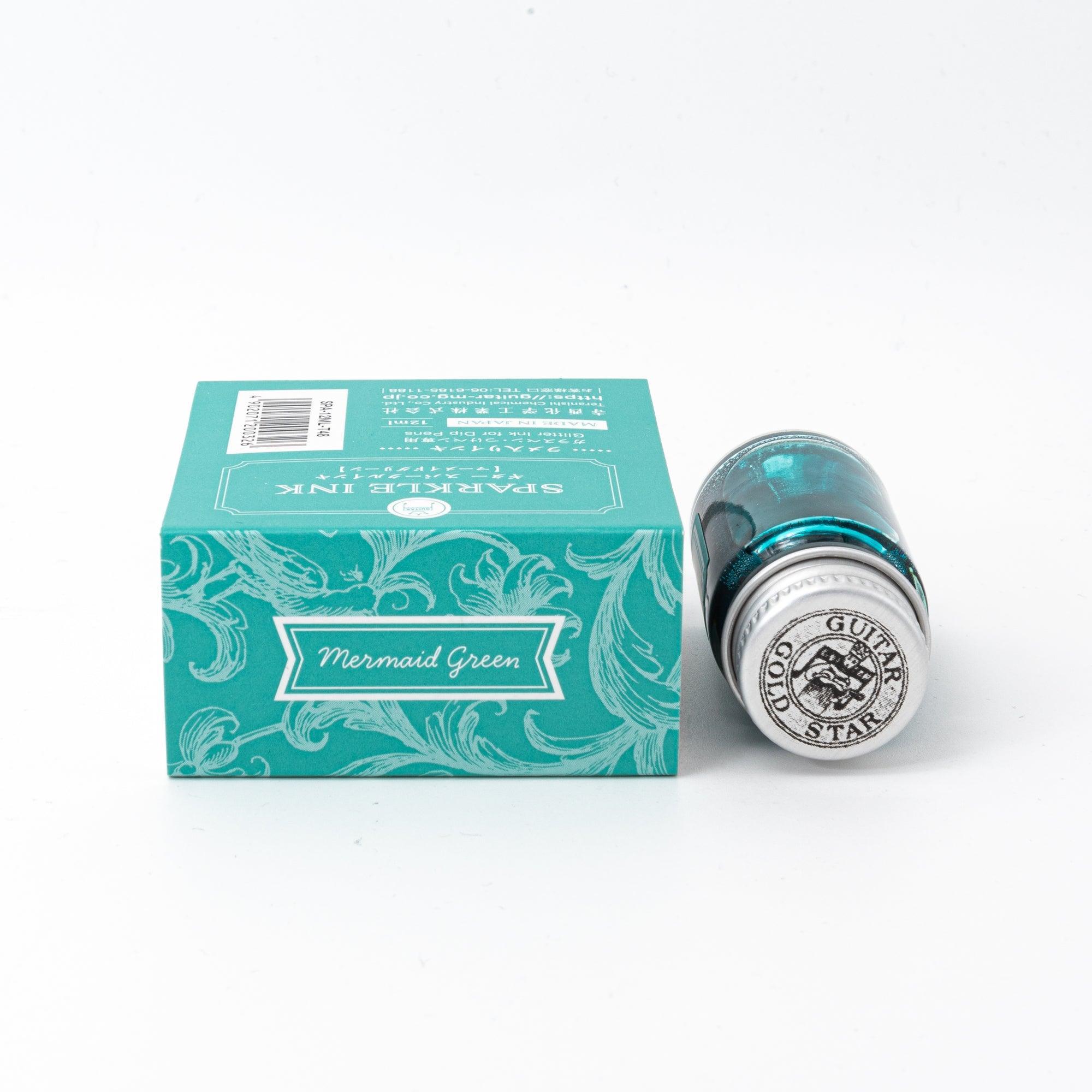 Sparkle Ink in Mermaid Green, presented in a glass bottle with coordinating green packaging featuring ornate floral patterns and