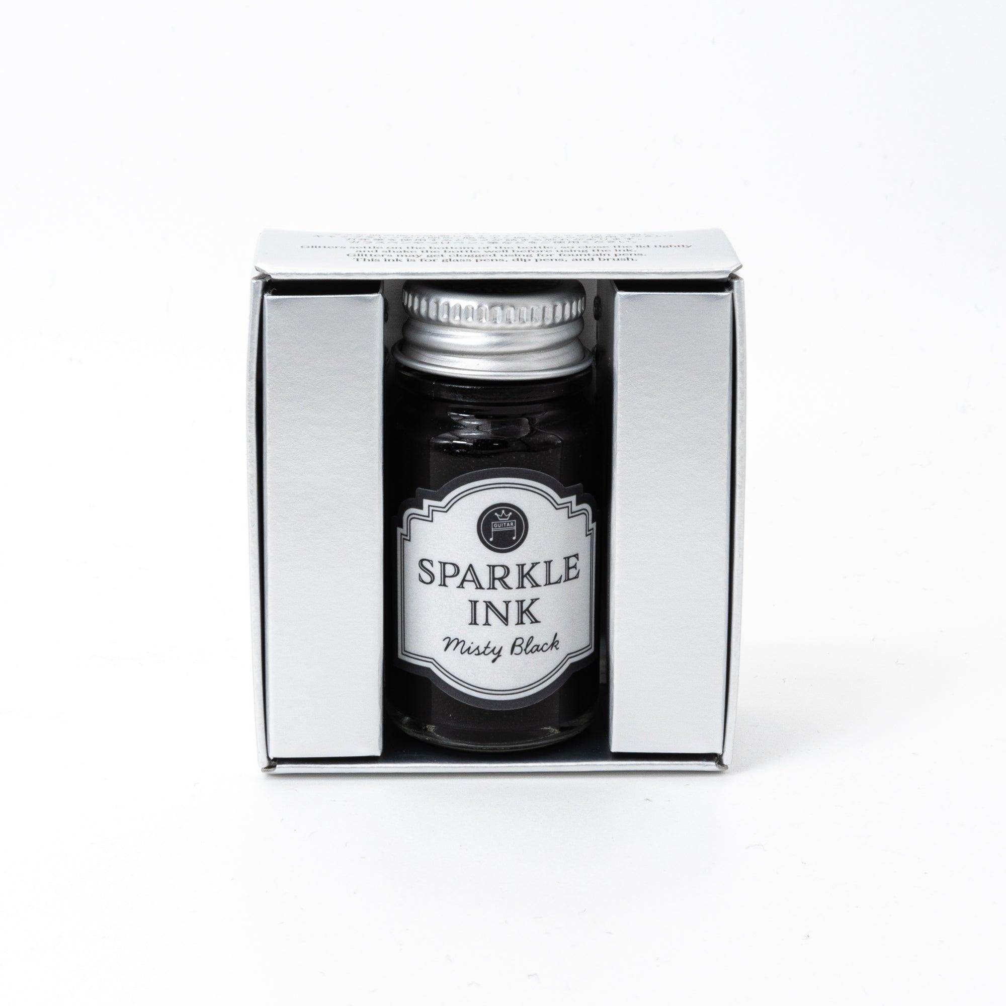 A bottle of Sparkle Ink in Misty Black, paired with its matching decorative box, featuring elegant floral patterns in monochrome design.